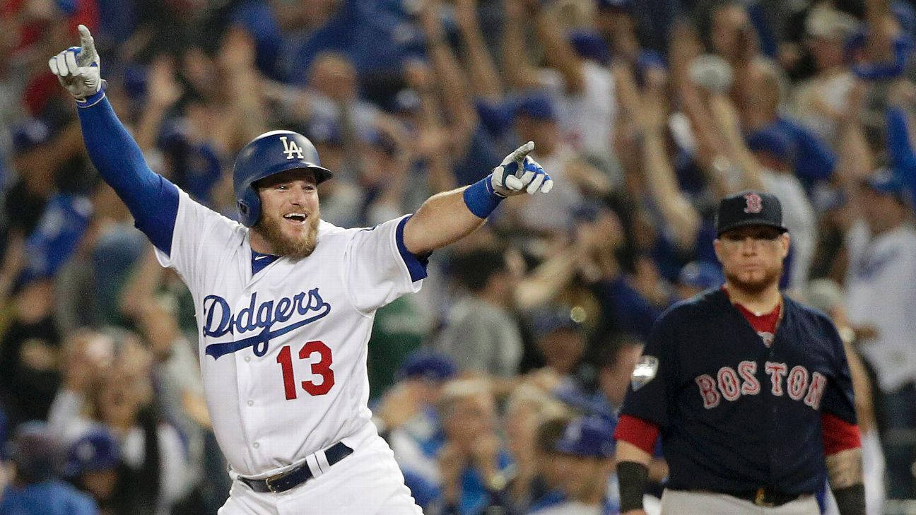 棒球選手在球場人群中高舉雙臂慶祝勝利。