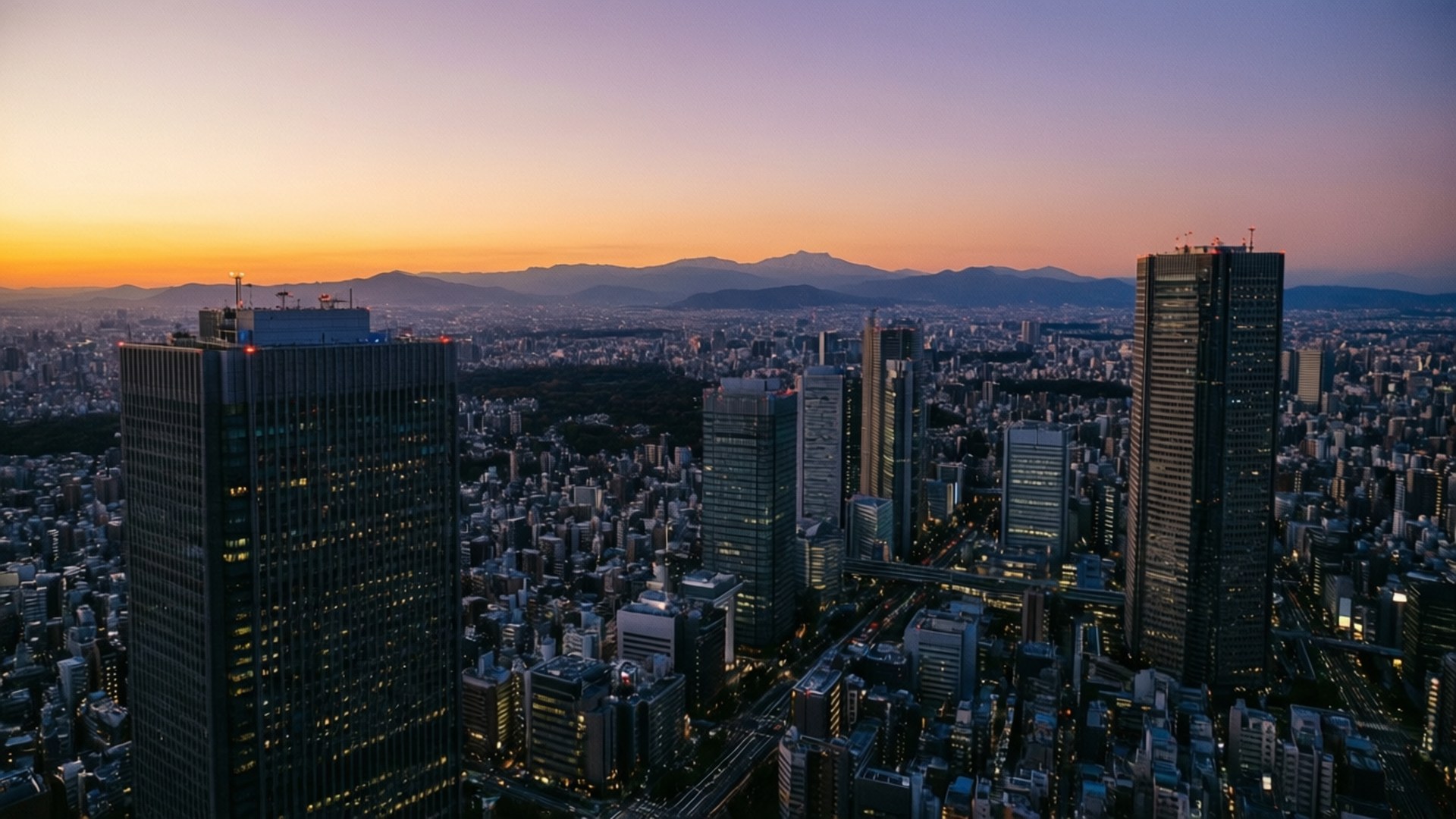 黃昏時分的東京城市景觀，在紫橙色天空下，有發光的摩天大樓和遠山