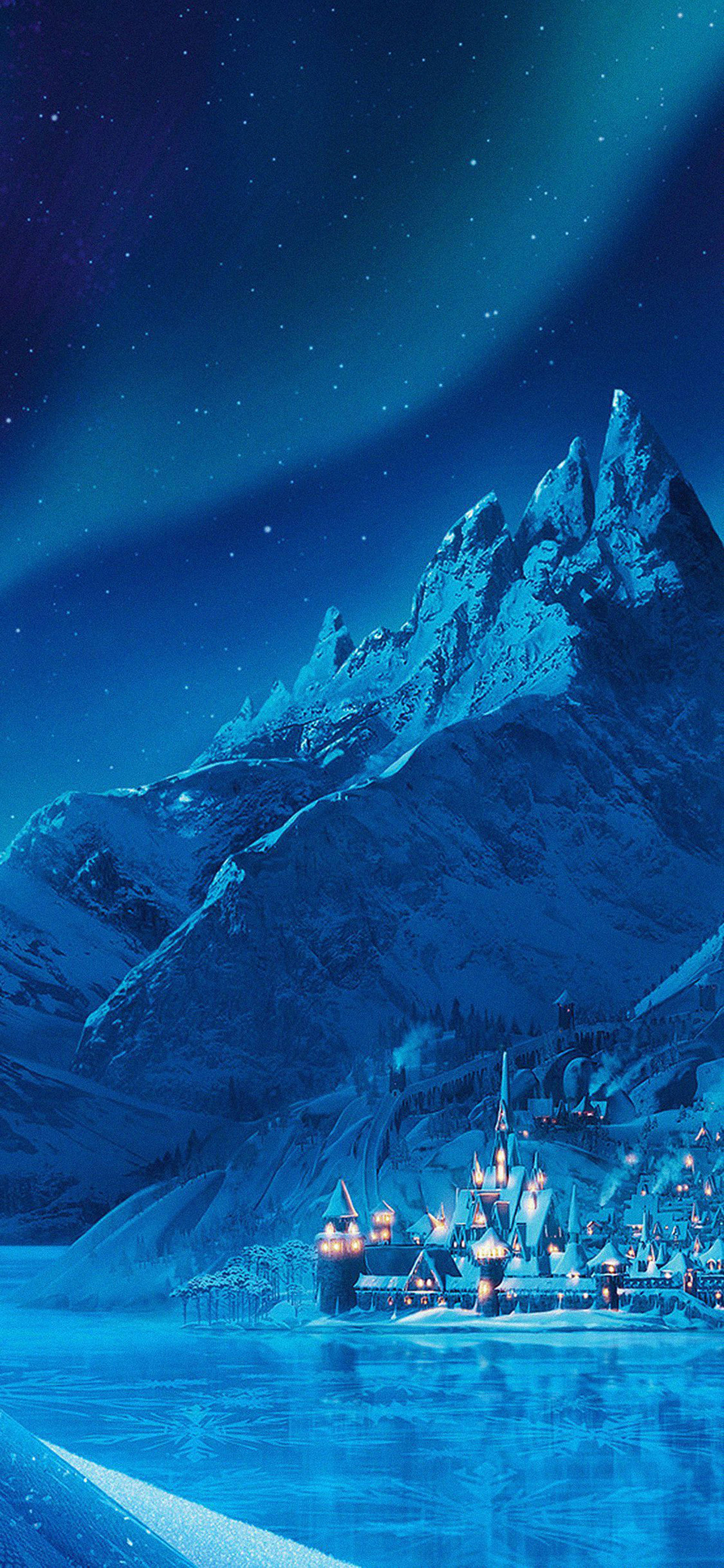 阿倫黛爾冰封城堡山脈 壁紙 — 一個被雪覆蓋的山村在繁星點點的夜空下溫暖地發光，北極光在上方舞動。
