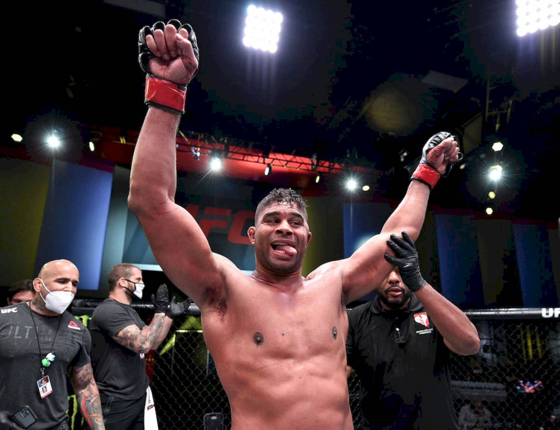 UFC拳手在八角籠內高舉雙臂慶祝勝利。