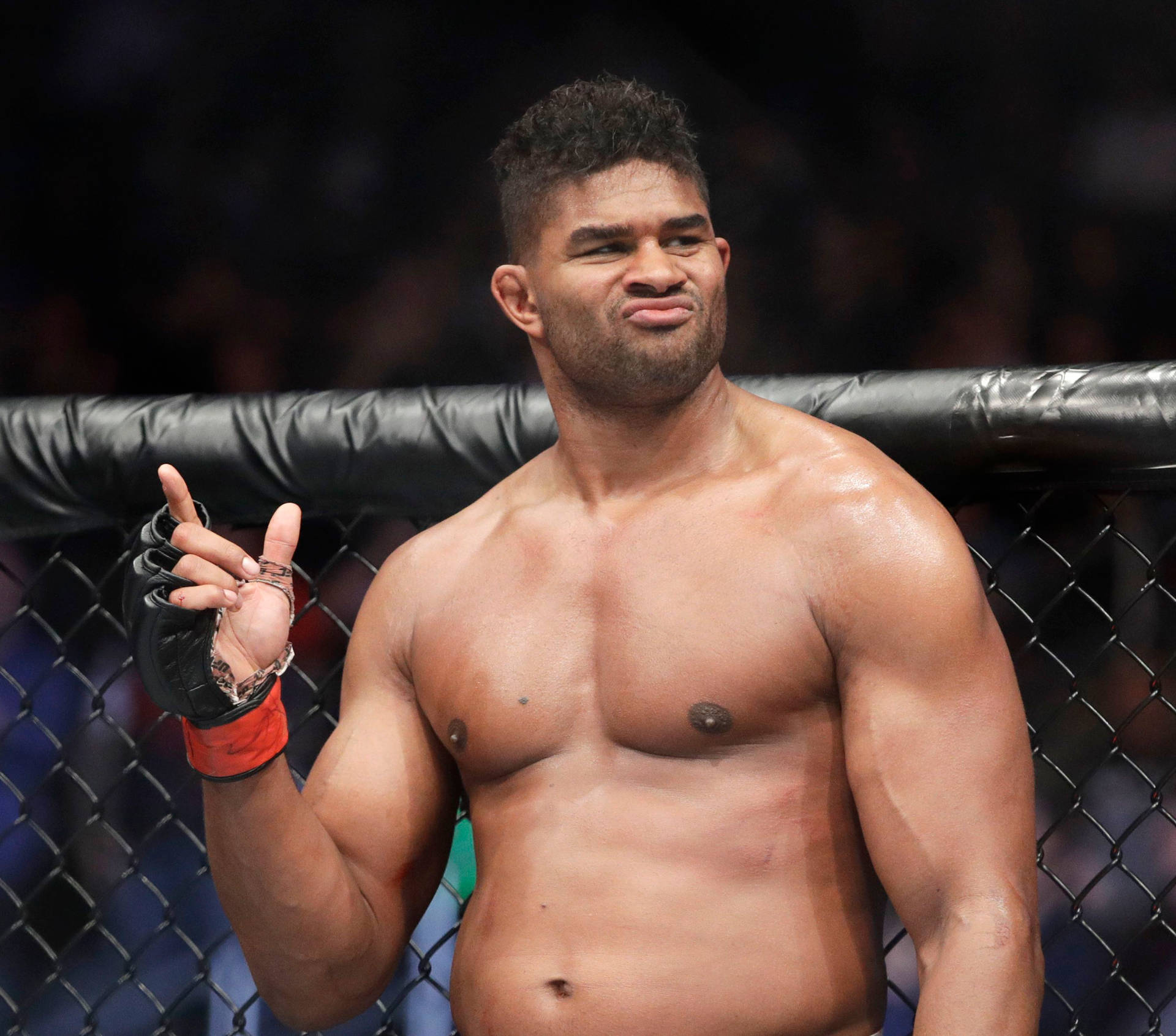 肌肉發達的MMA拳手在鐵籠內做出和平手勢並微笑