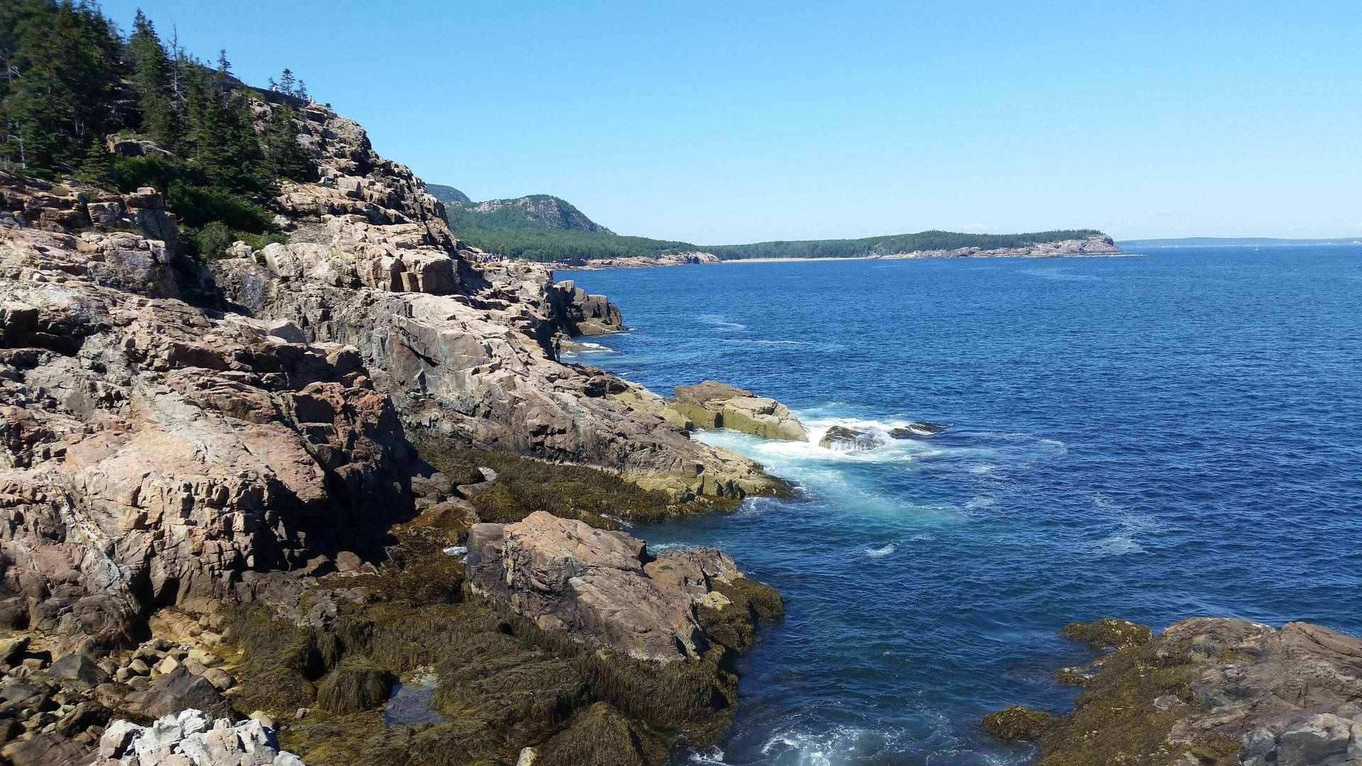 崎嶇海岸懸崖，拍岸浪濤和清澈藍天。
