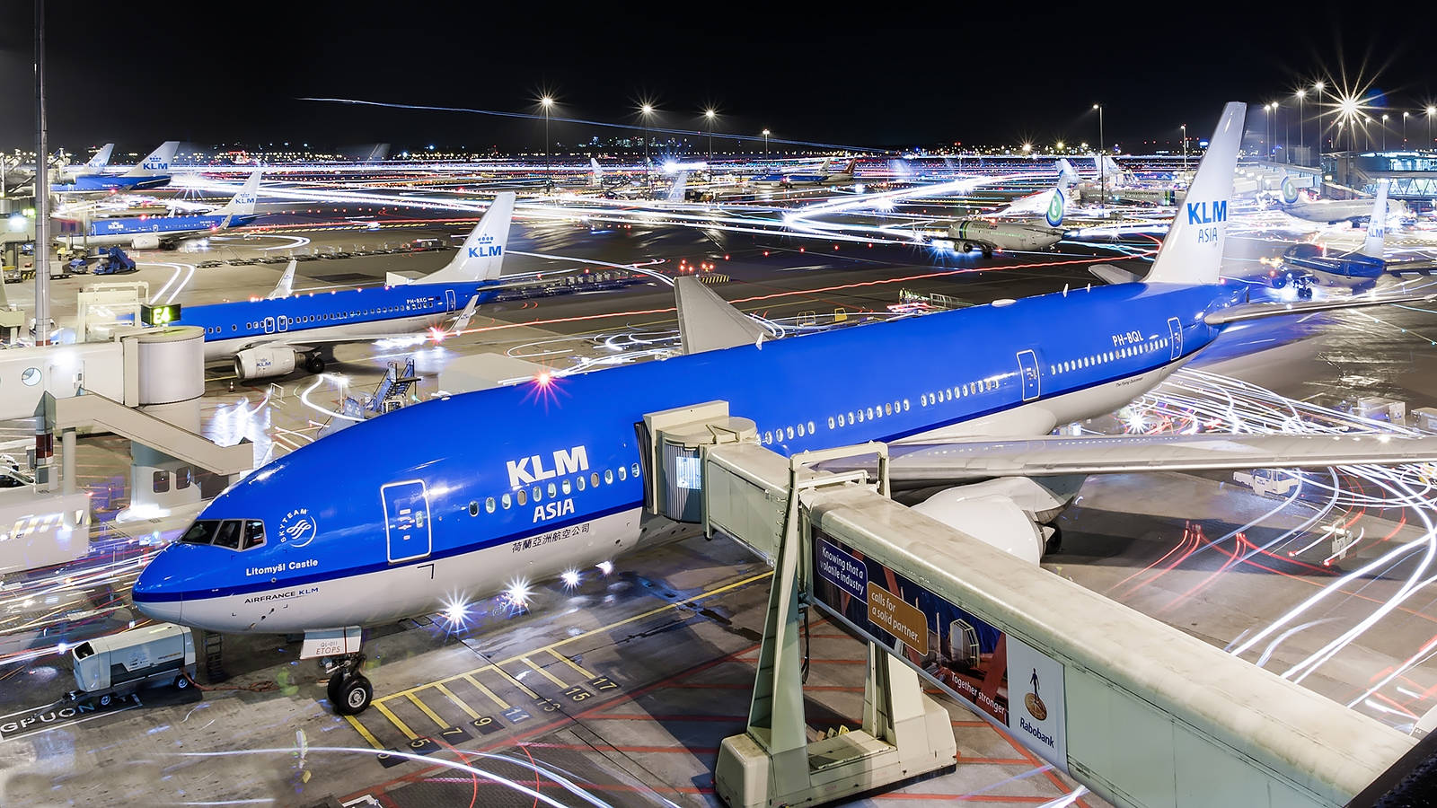 夜間停泊的KLM亞洲飛機及機場車輛光軌。