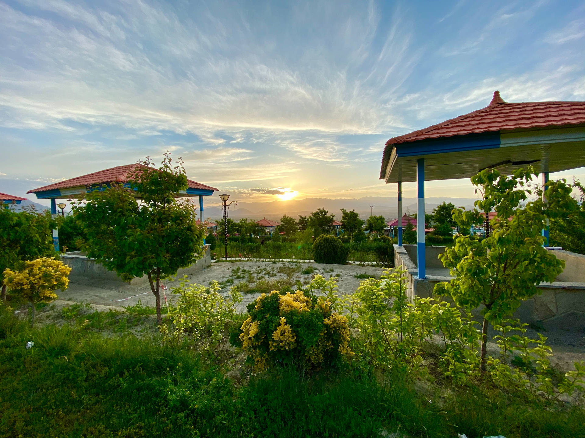 公園涼亭在夕陽下，綠植和遠山
