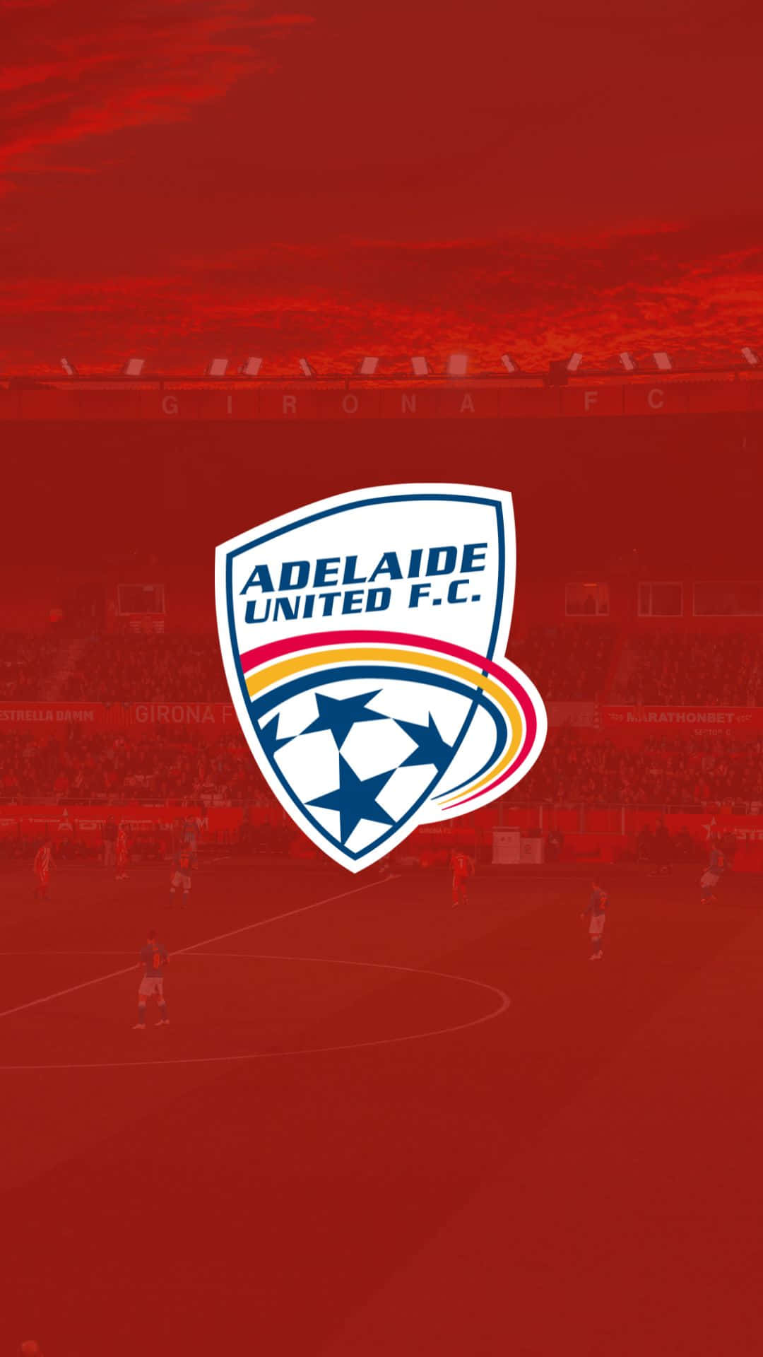 Adelaide United 桌布 壁紙 — 阿德萊德聯足球會標誌居中，置於帶有紅色色調的足球場場景及場上球員之上。