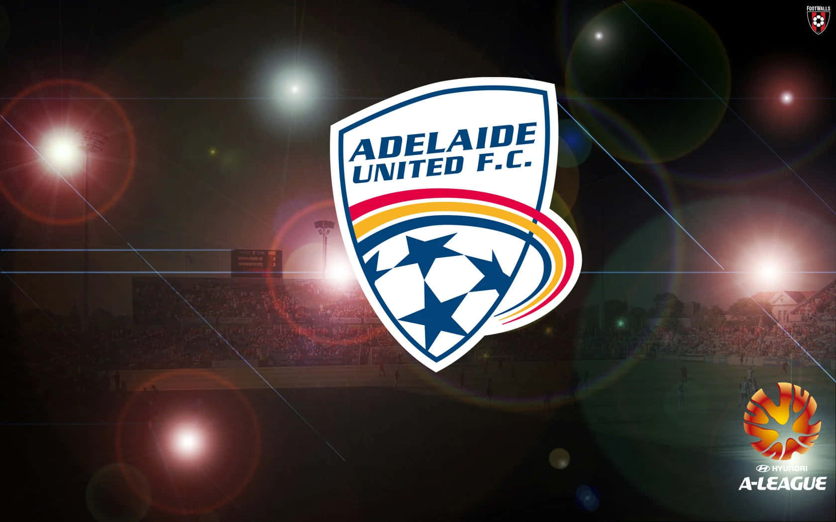Adelaide United 桌布 壁紙 — 阿德萊德聯足球會標誌置中於夜間球場，帶有發光聚光燈和鏡頭眩光。