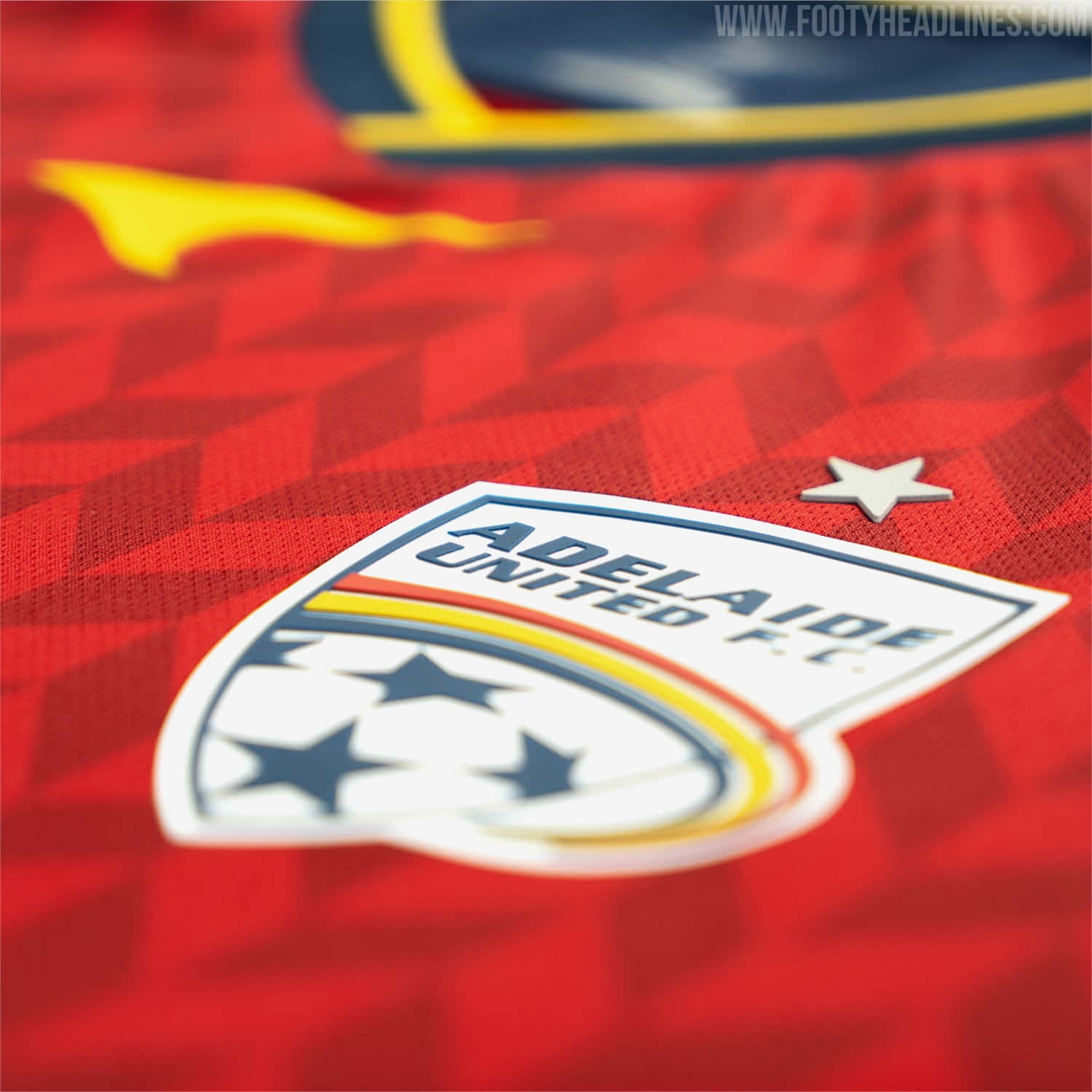 Adelaide United 桌布 壁紙 — 阿德萊德聯足球會球衣特寫，紅色幾何圖案和球隊徽章清晰可見。