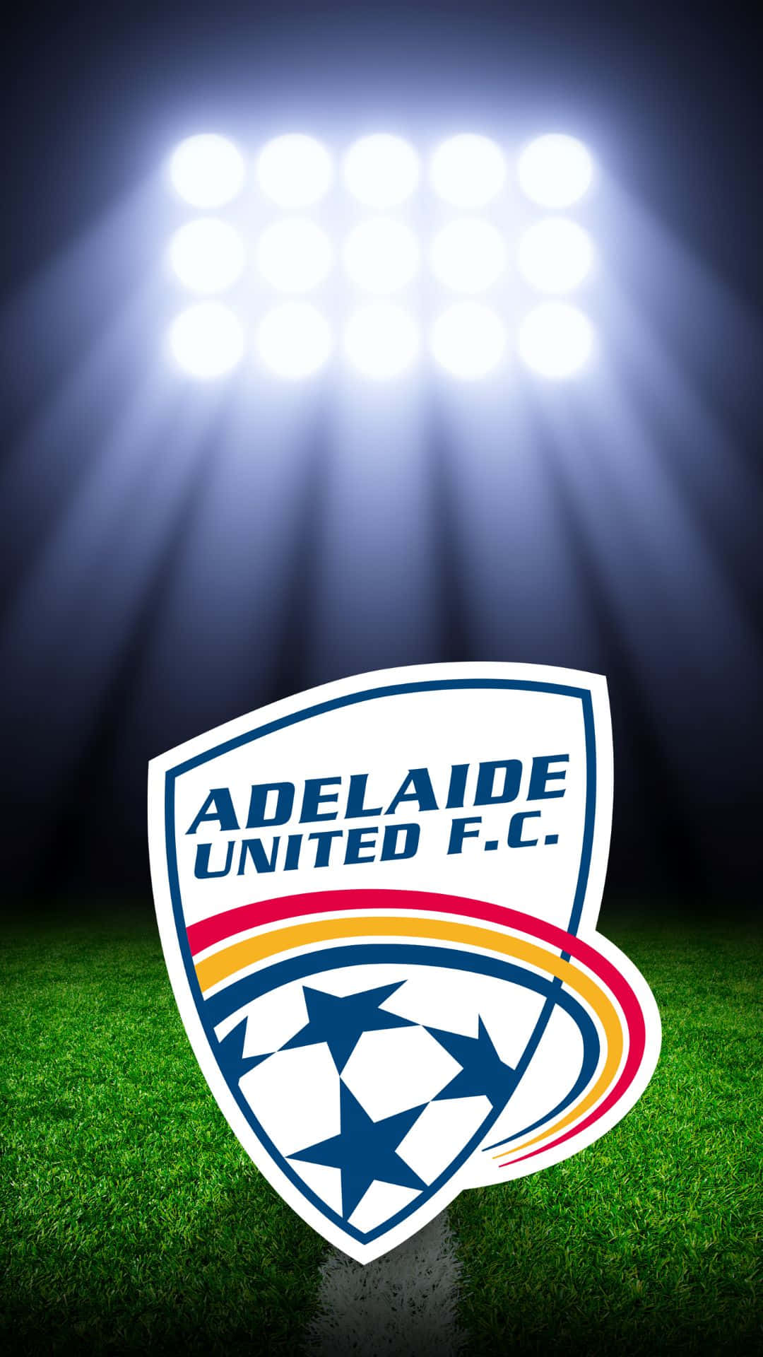 Adelaide United 桌布 壁紙 — 阿德萊德聯足球會的會徽在翠綠草地上於球場燈光下閃耀。