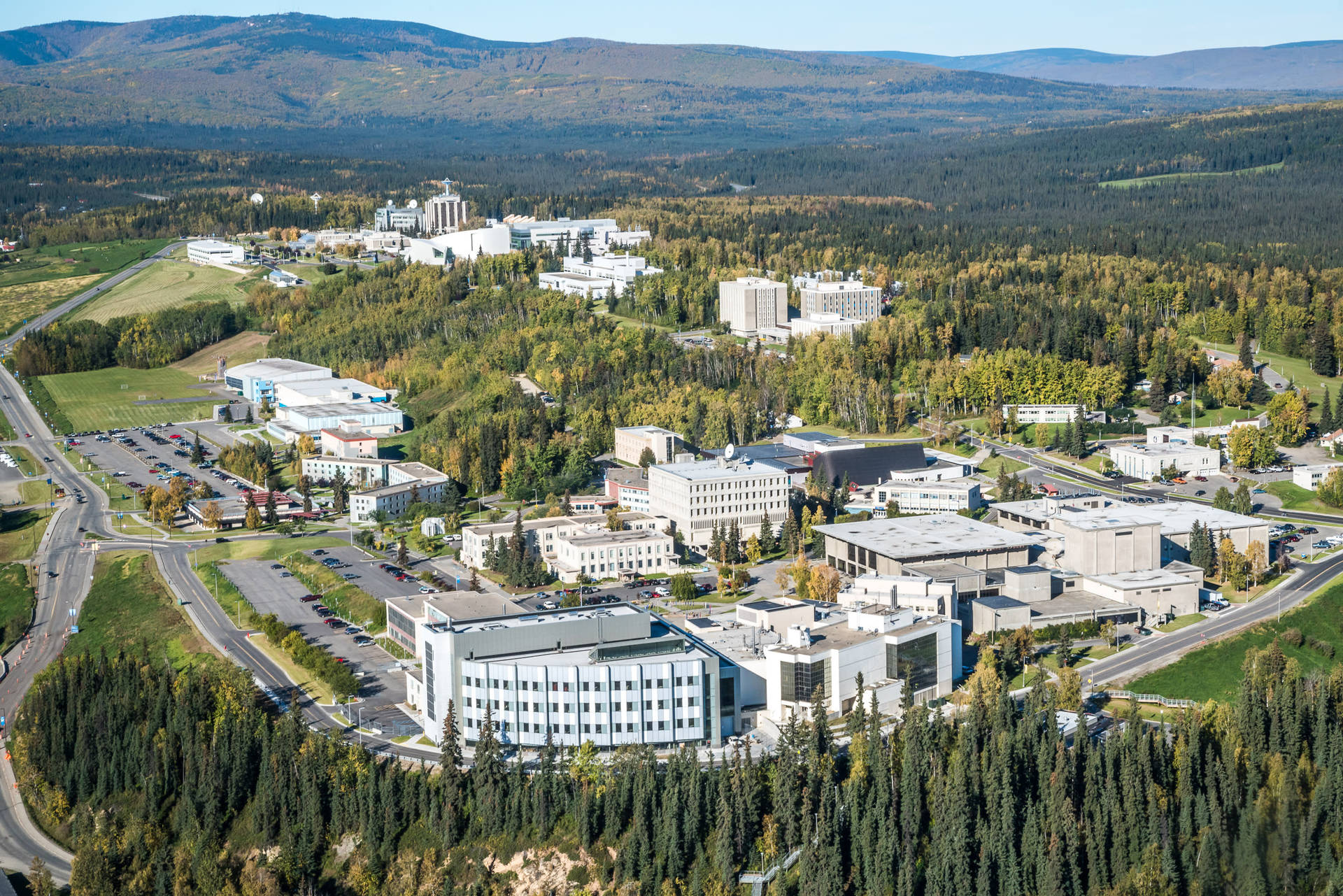大學校園的鳥瞰圖，被秋林和山脈環繞。