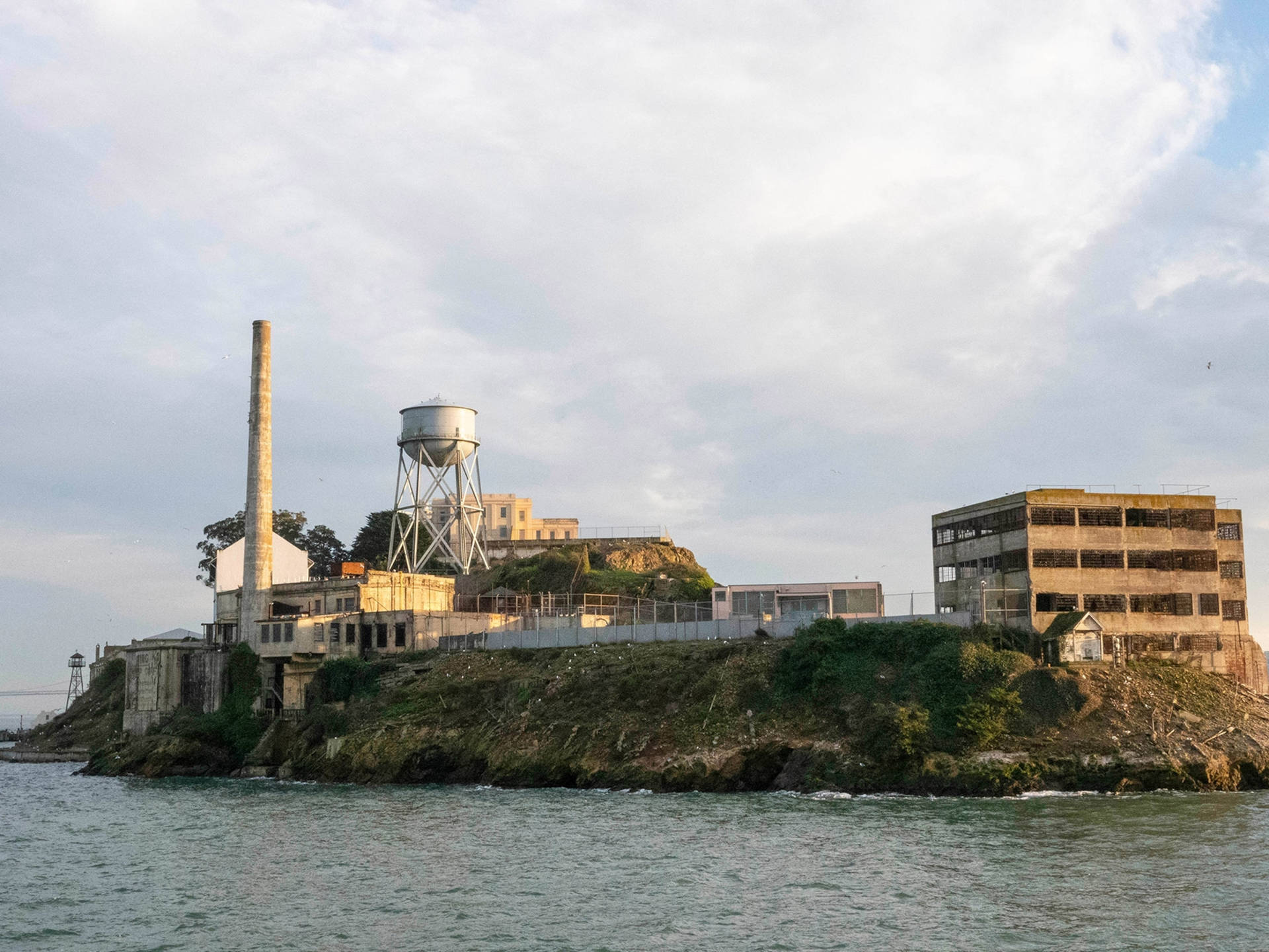 黃昏時分的惡魔島監獄建築群，海水和陰雲天空