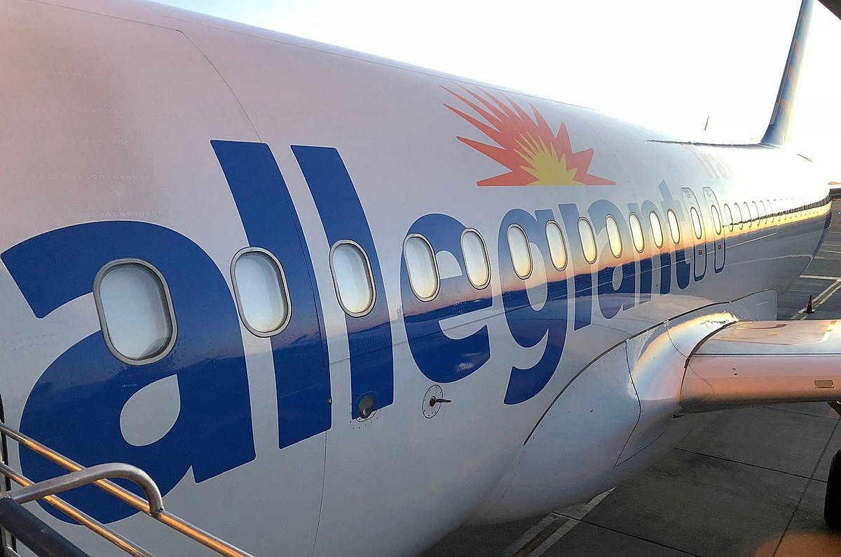 Allegiant Air 飛機機身，帶有標誌和乘客窗戶，在機場停機坪上。