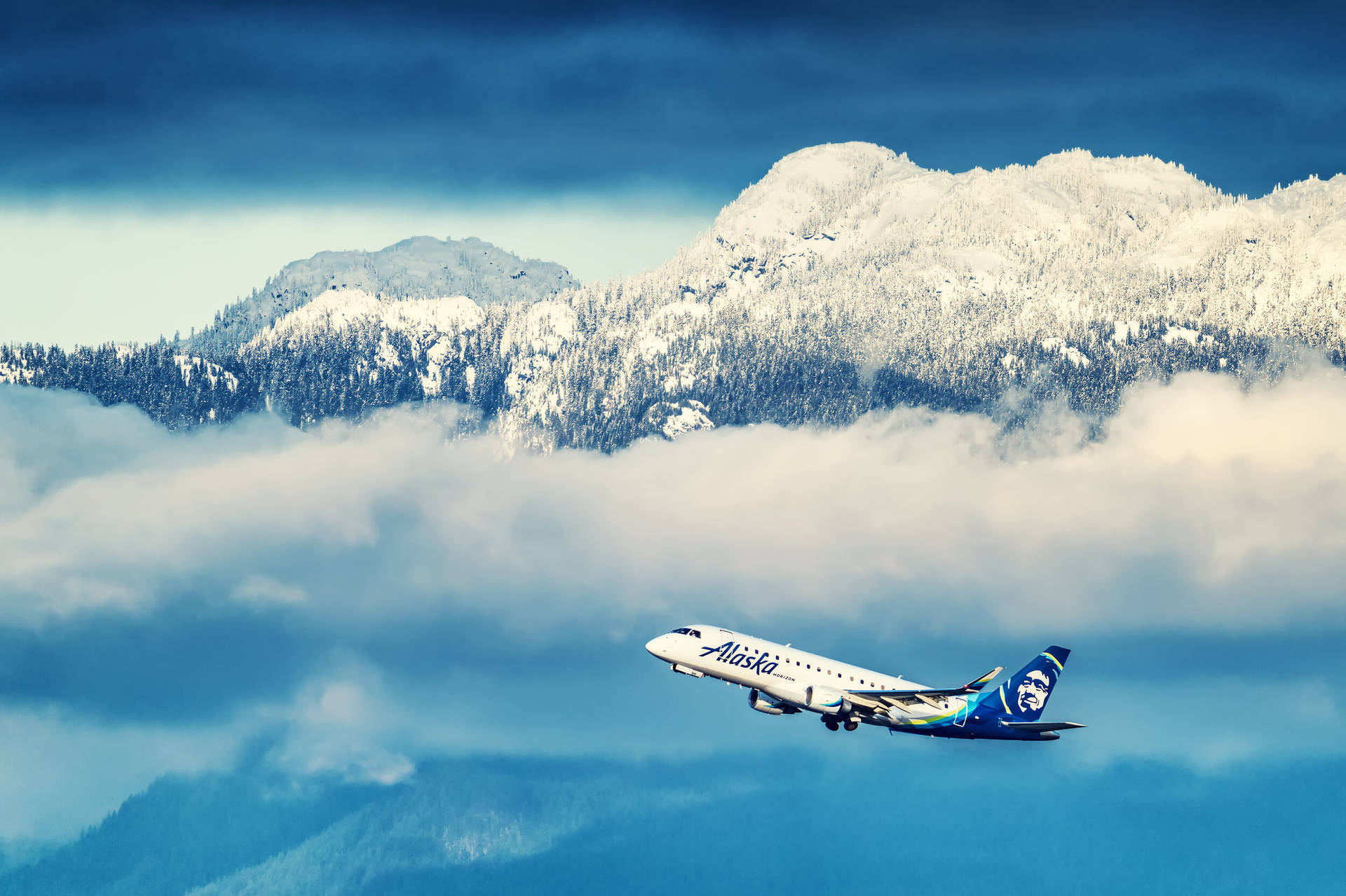 阿拉斯加航空飛機飛越雪山和雲層。