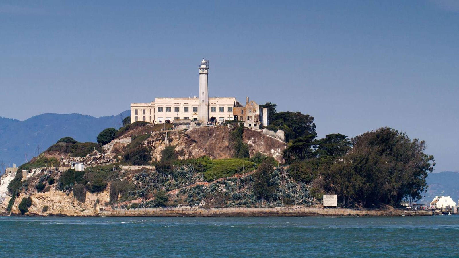 阿爾卡特拉斯島上的監獄建築和燈塔，位於藍色海水中。