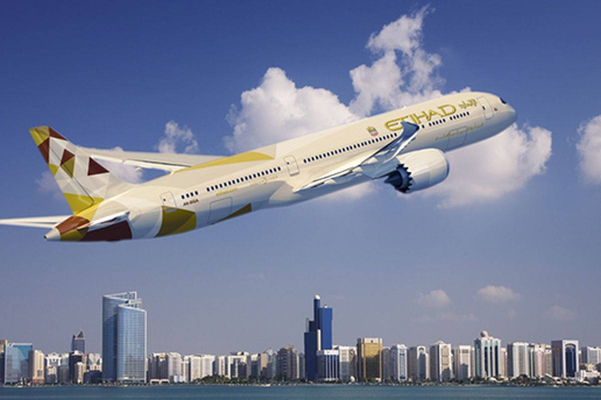 阿提哈德航空飛機飛越擁有摩天大樓和水域的現代城市。