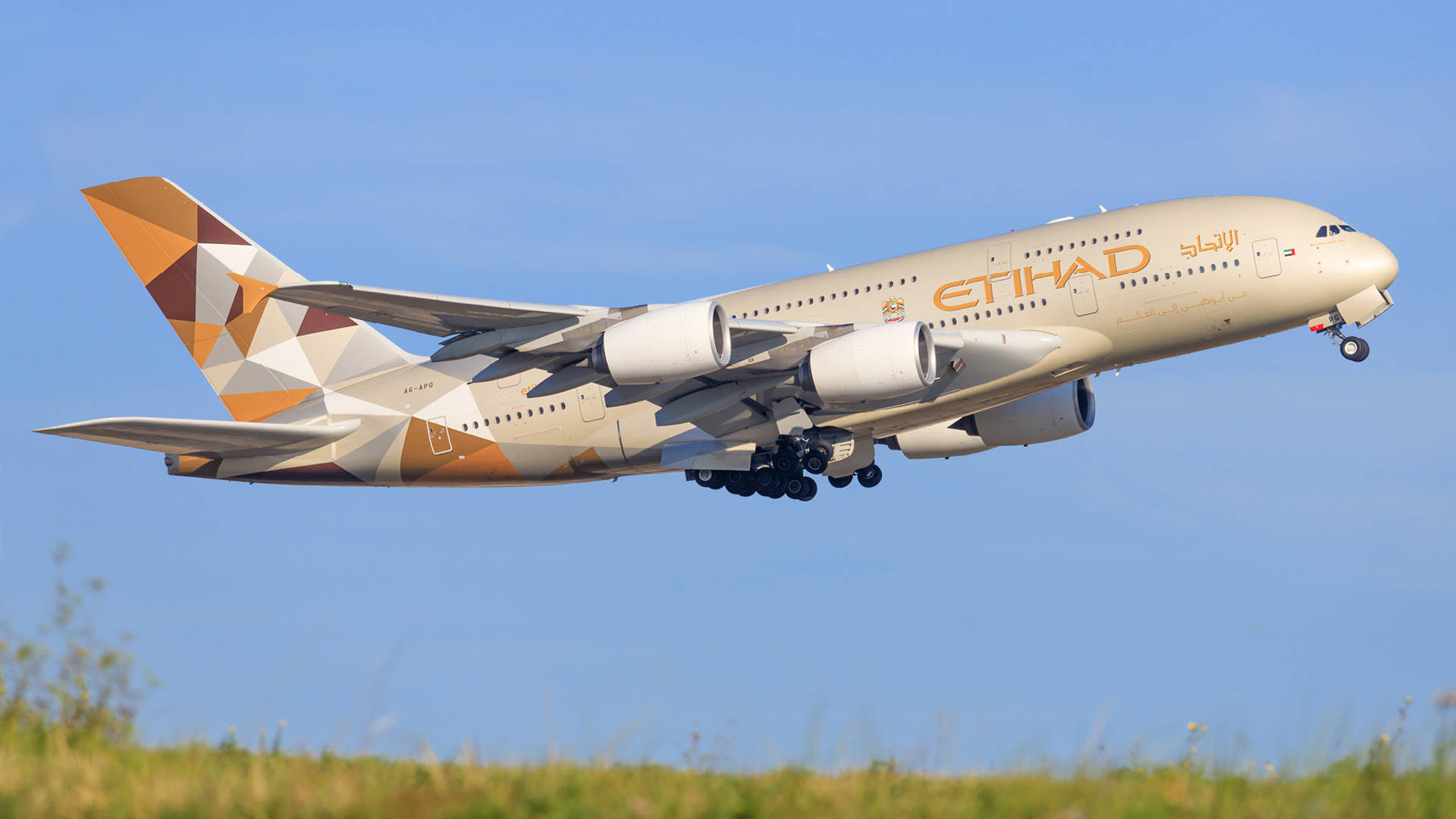 阿提哈德航空A380飛機在藍天下從綠色草地上起飛