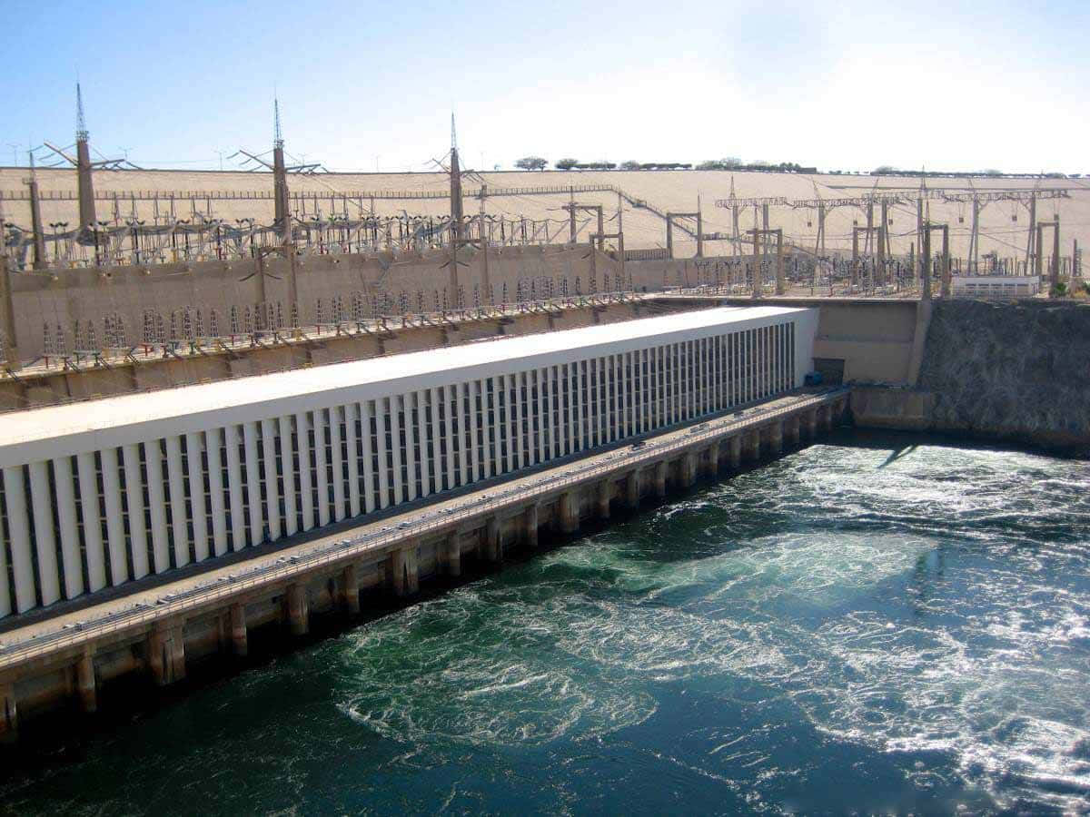 大型水力發電大壩釋放水流，上方有輸電線。