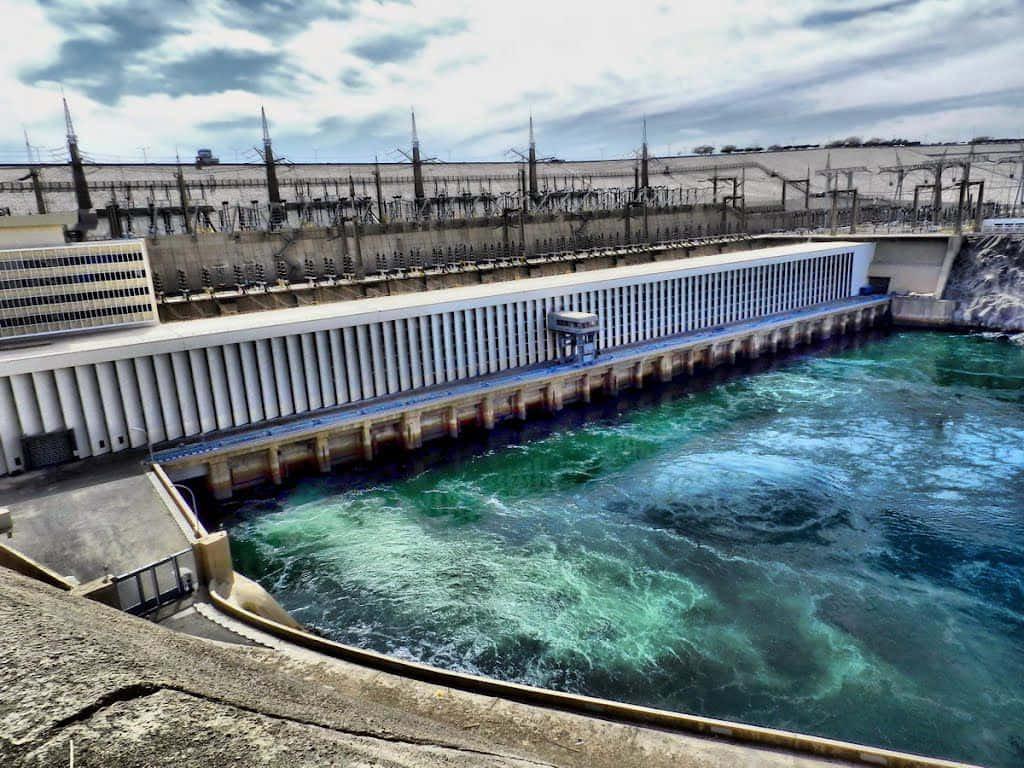 在陰天之下將水排放到河流中的大型水力發電水壩。