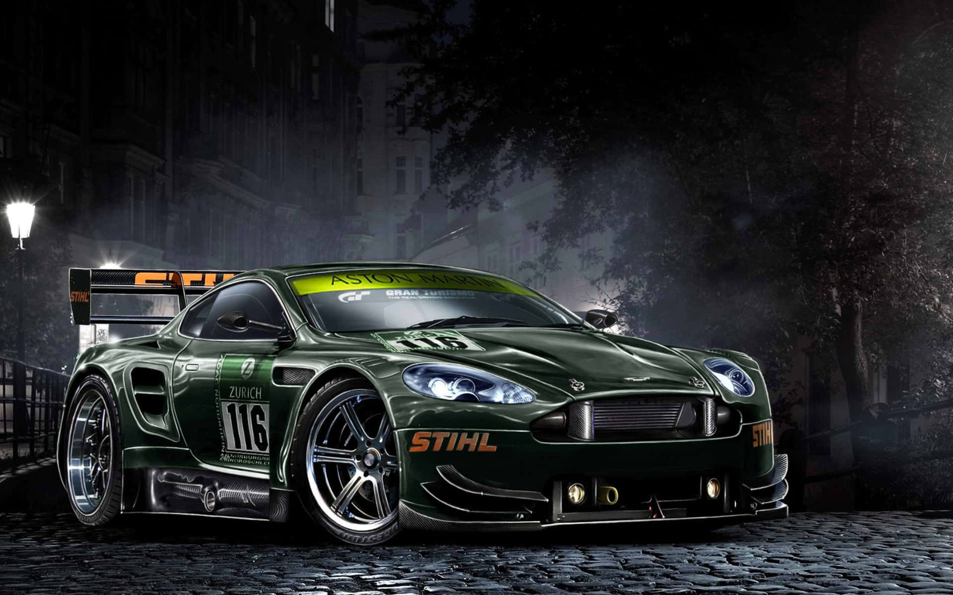 阿斯特羅·馬丁街頭賽車 壁紙 — 一輛時尚的綠色Aston Martin賽車，編號116，在夜晚霧氣籠罩的鵝卵石城市街道上，在街燈下閃耀。