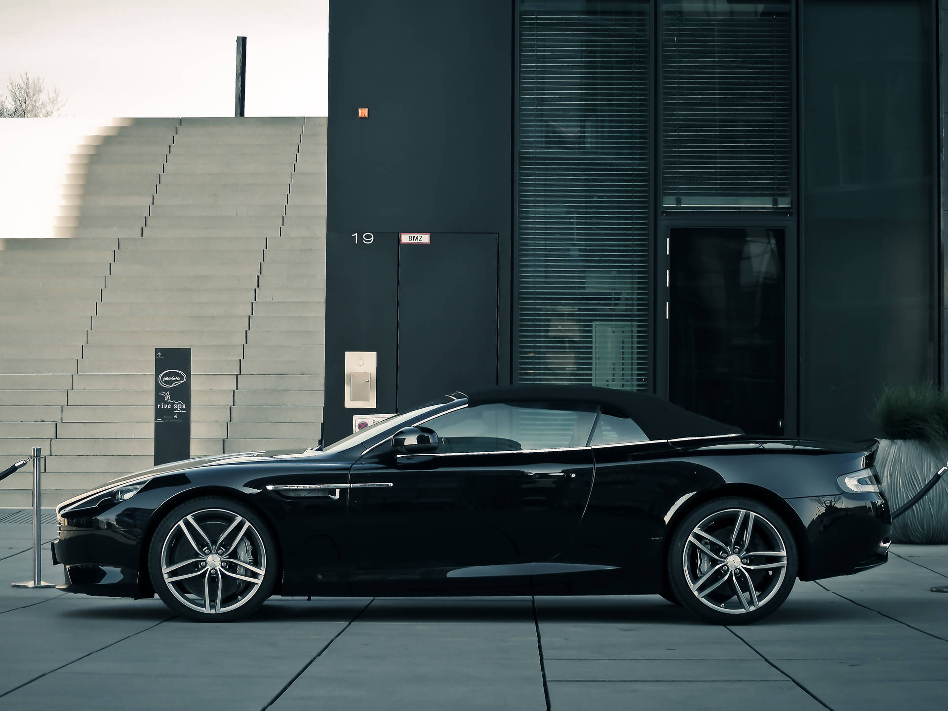 黑色Aston Martin開篷車停泊在現代建築前