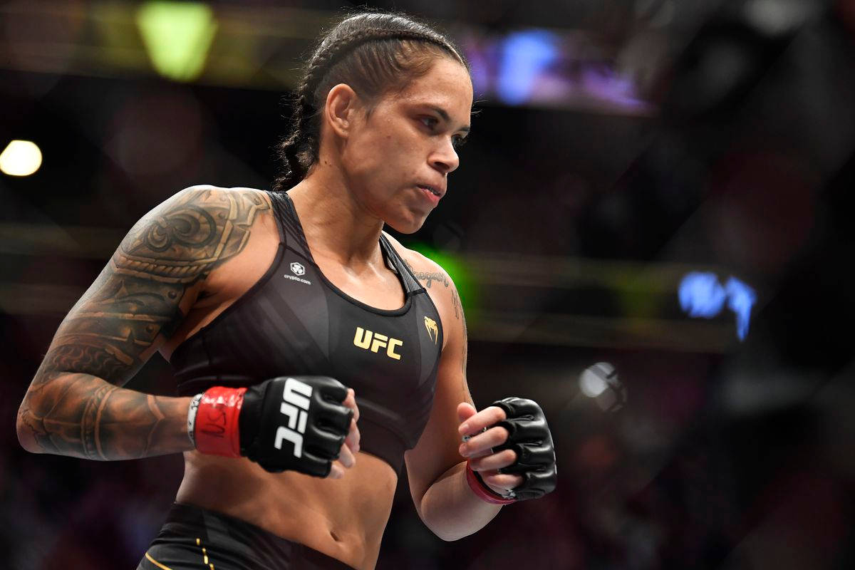 身穿黑色UFC裝備、帶有紋身的女MMA拳手正在準備戰鬥。