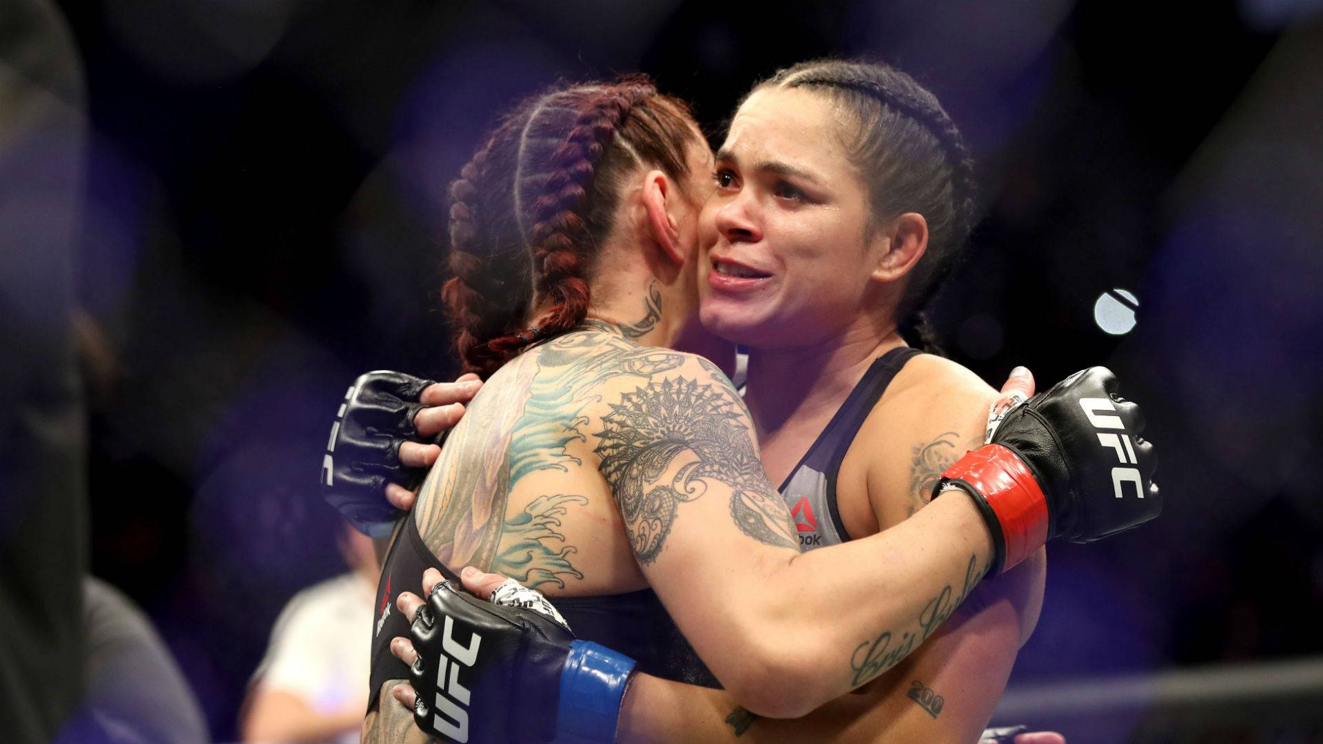 兩位女性MMA拳手在八角籠內賽後擁抱。