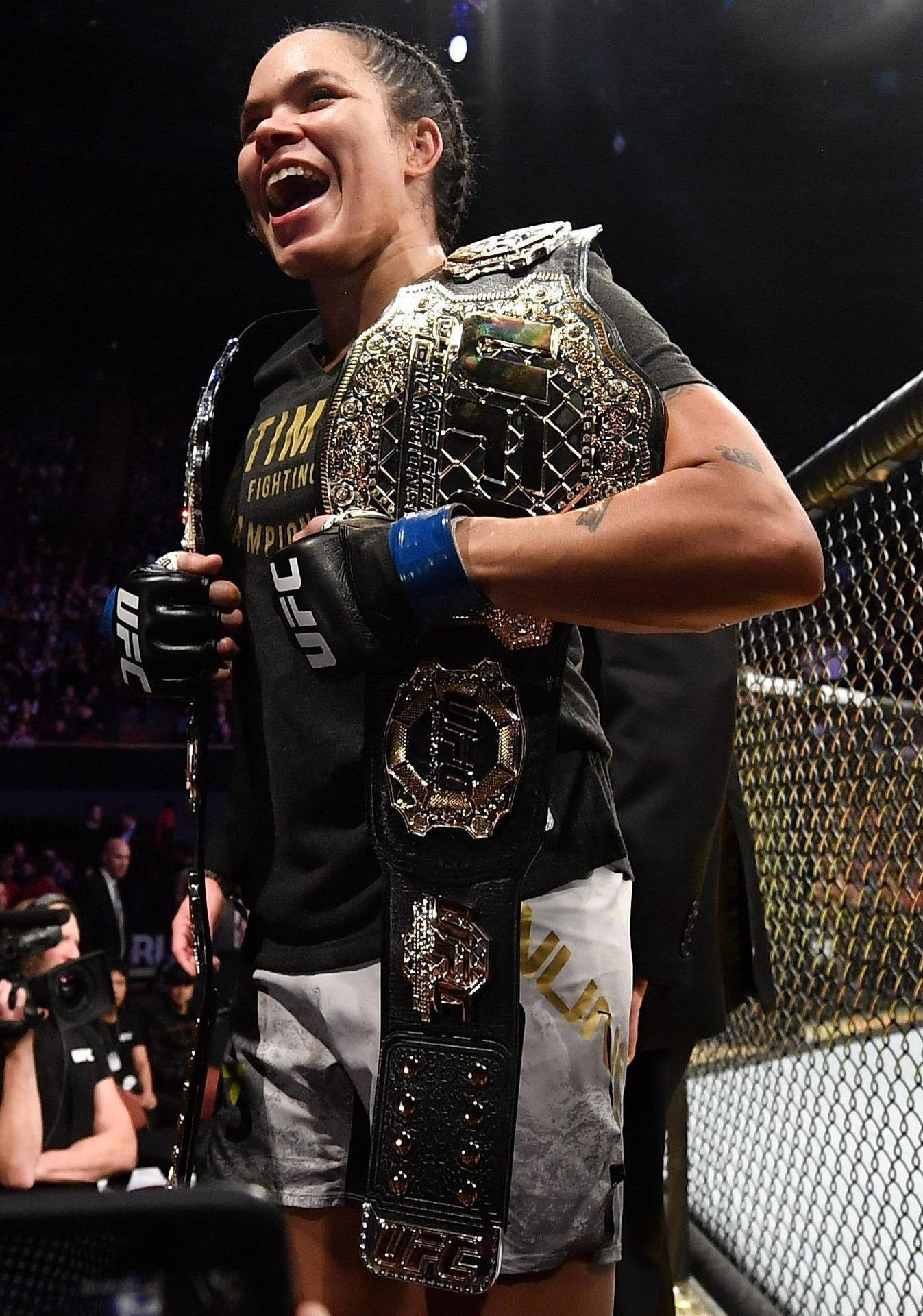UFC拳手在八角籠內手持冠軍腰帶慶祝勝利。