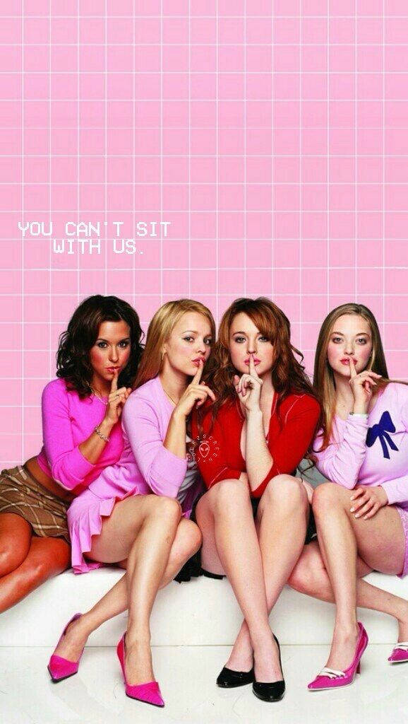 四個穿著粉紅色服裝的女孩坐著做出噓的手勢，並帶有文字「YOU CAN'T SIT WITH US。」