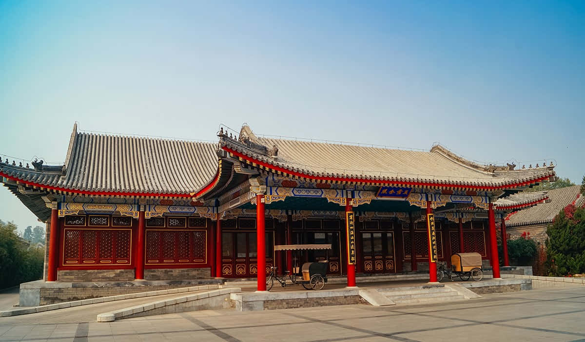 阿曼頤和園清晨風景 壁紙 — 傳統中式亭閣，紅色柱子，灰色瓦頂，襯托晴朗藍天。