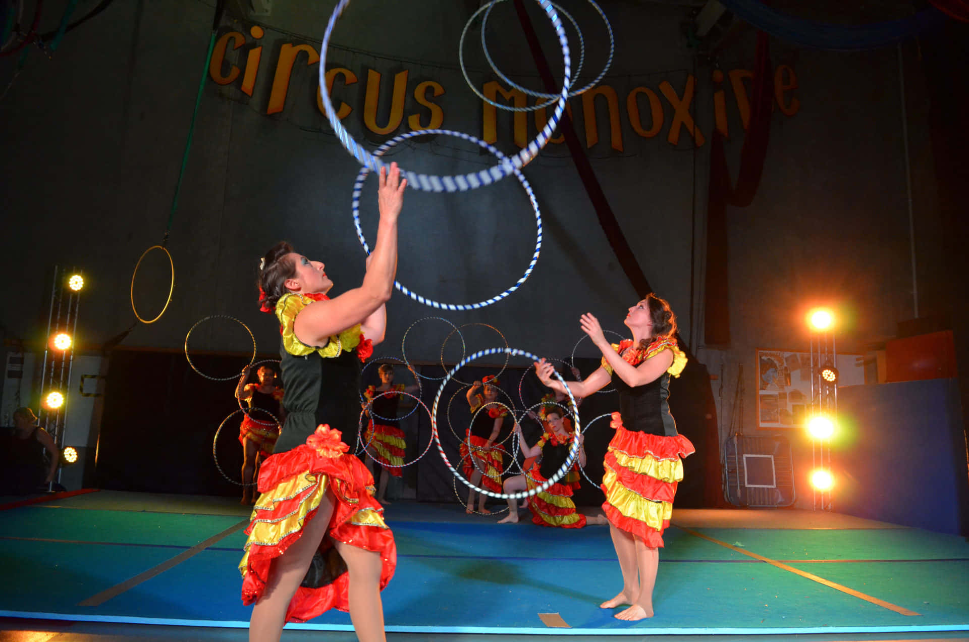 馬戲團表演者在明亮的舞台上旋轉發光的環圈。