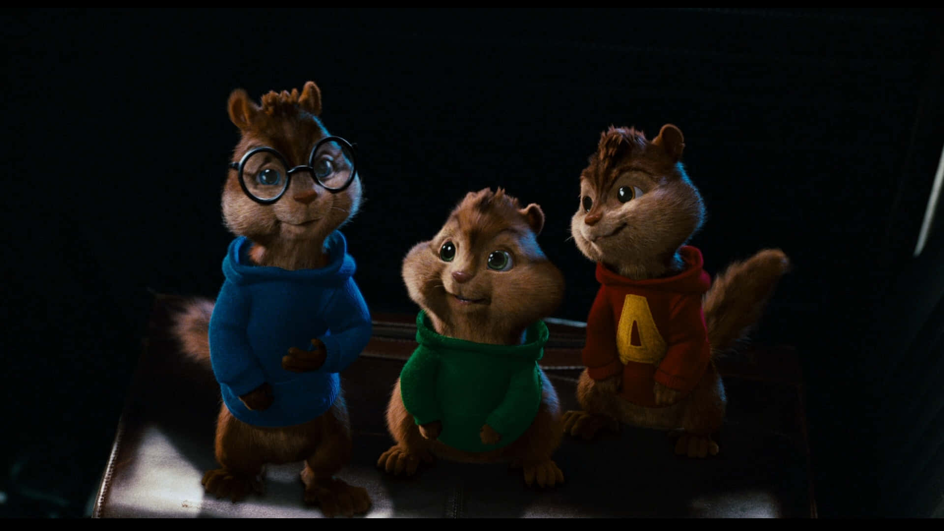 三隻穿著連帽衫的花栗鼠在昏暗燈光下站在一起。 — 阿爾文與_chipmunks 壁紙