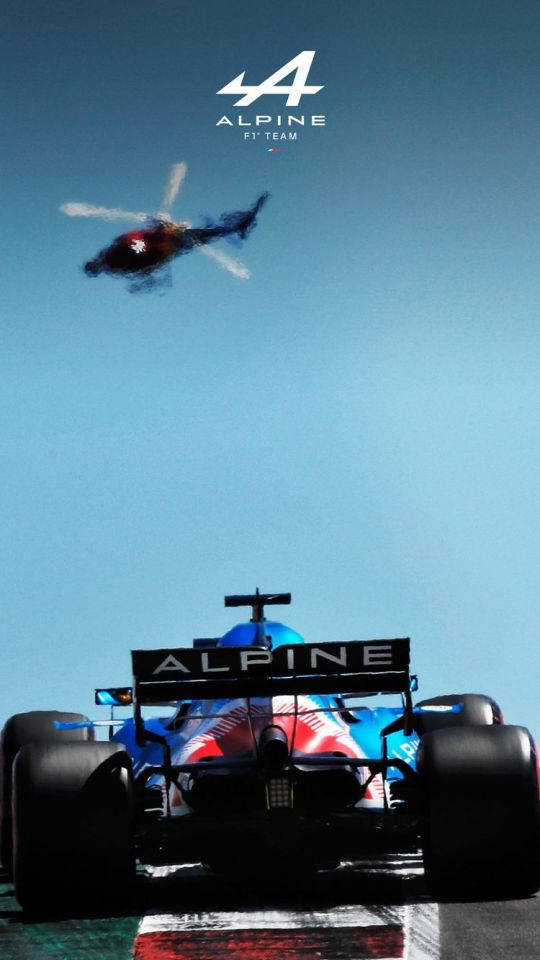 Alpine F1賽車在晴朗的日子裡與頭頂的直升機競速。