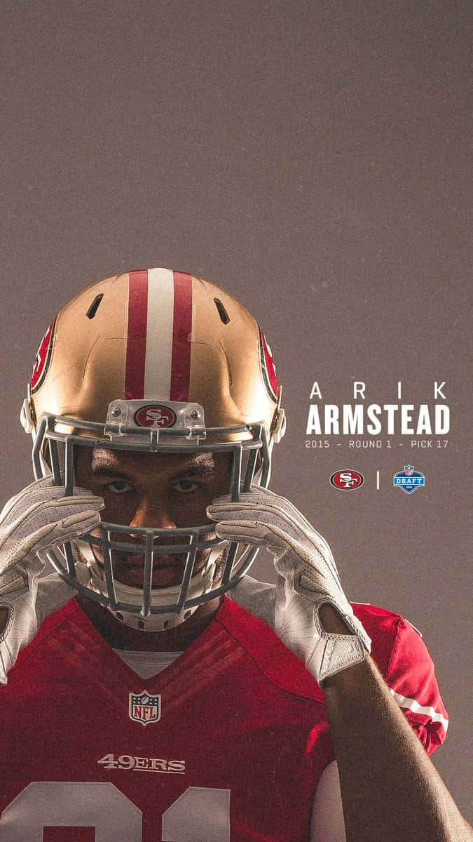 身穿49人隊球衣的足球運動員Arik Armstead舉起頭盔露出臉部。