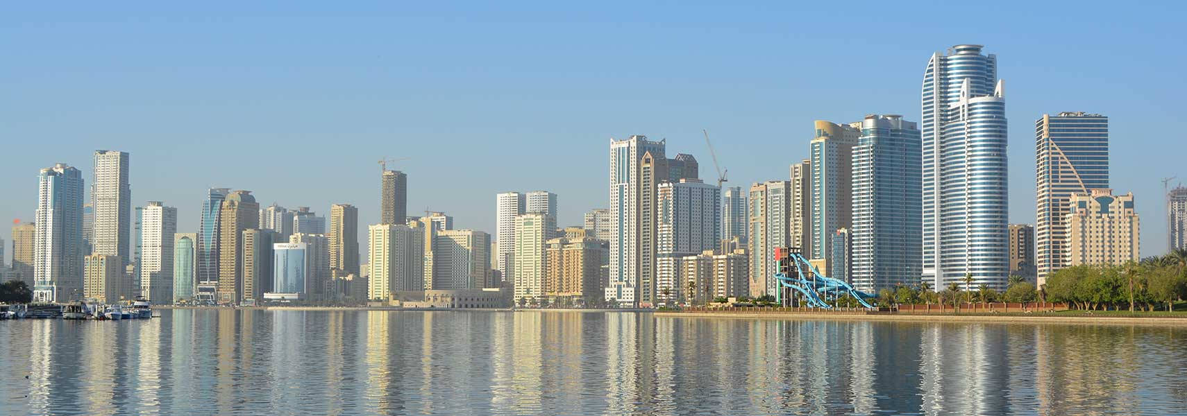晴朗天氣下，高樓倒映在水面上的城市天際線。