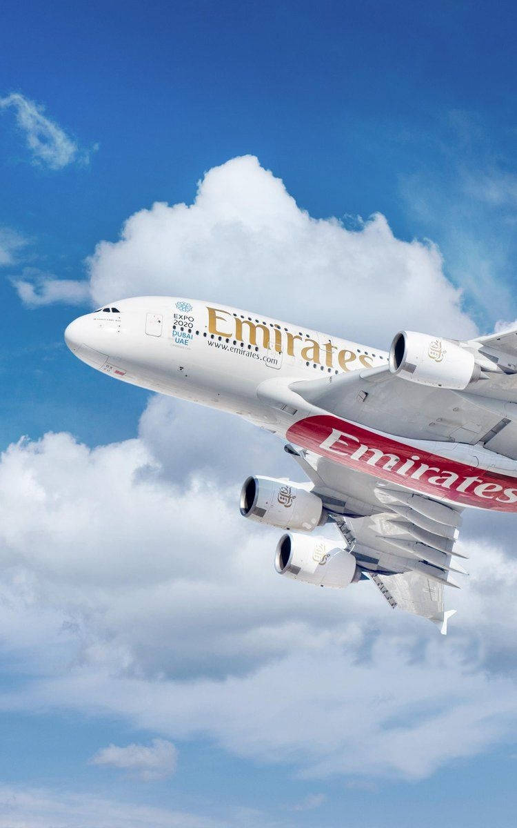 阿聯酋航空空中巴士A380在晴朗藍天中高高飛越蓬鬆白雲。