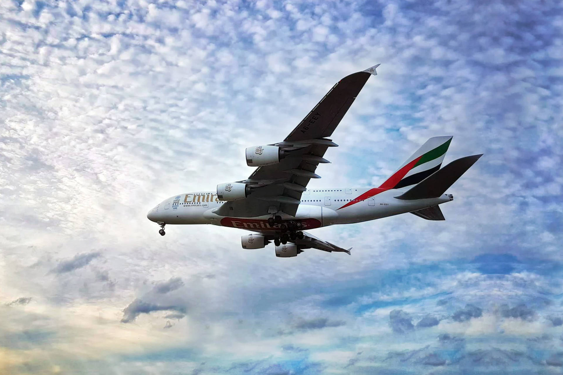 阿聯酋航空空中巴士A380在明亮的藍天中飛越蓬鬆的白雲。