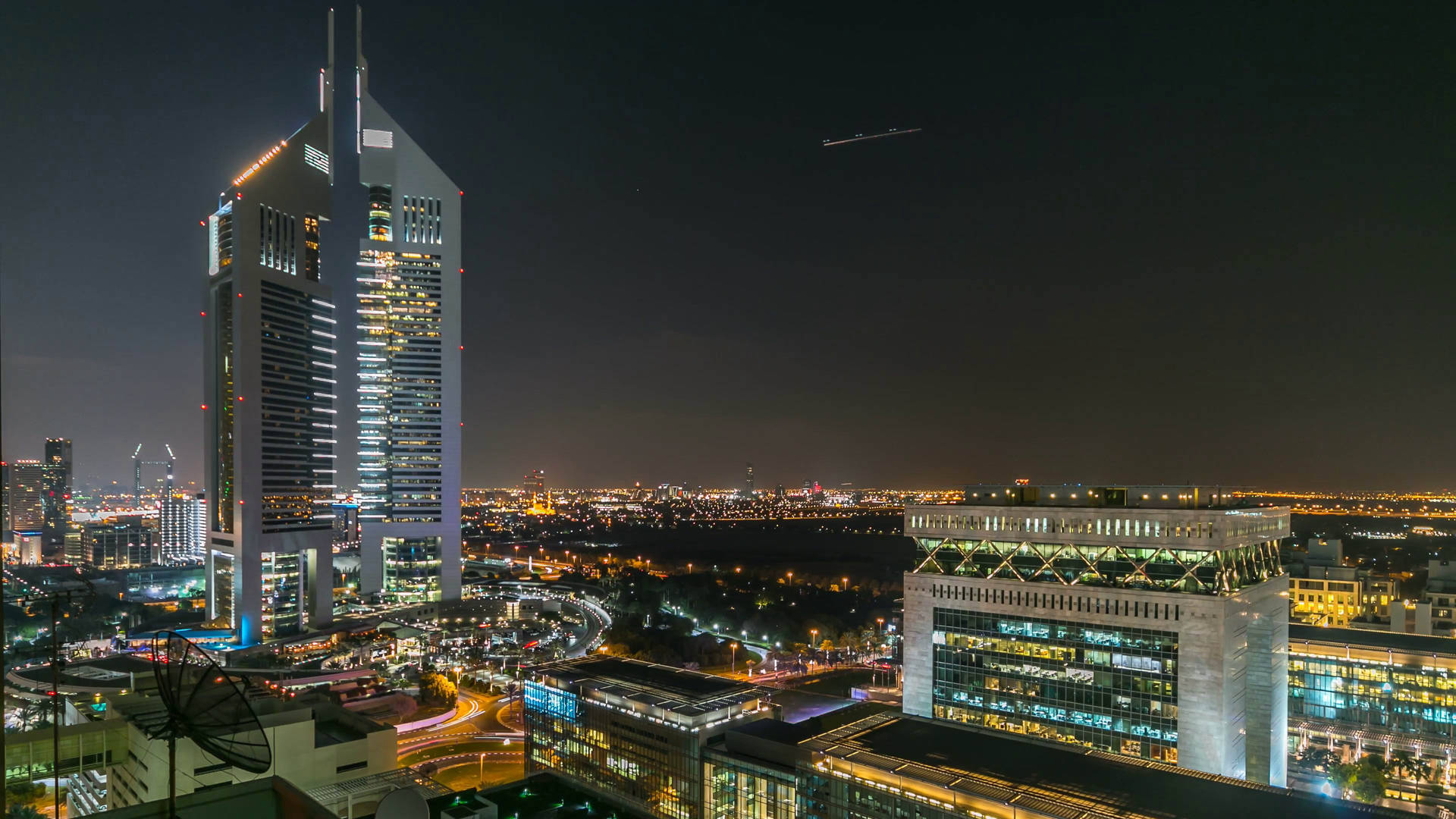 現代城市的夜景，有明亮的摩天大樓和發光的街道。