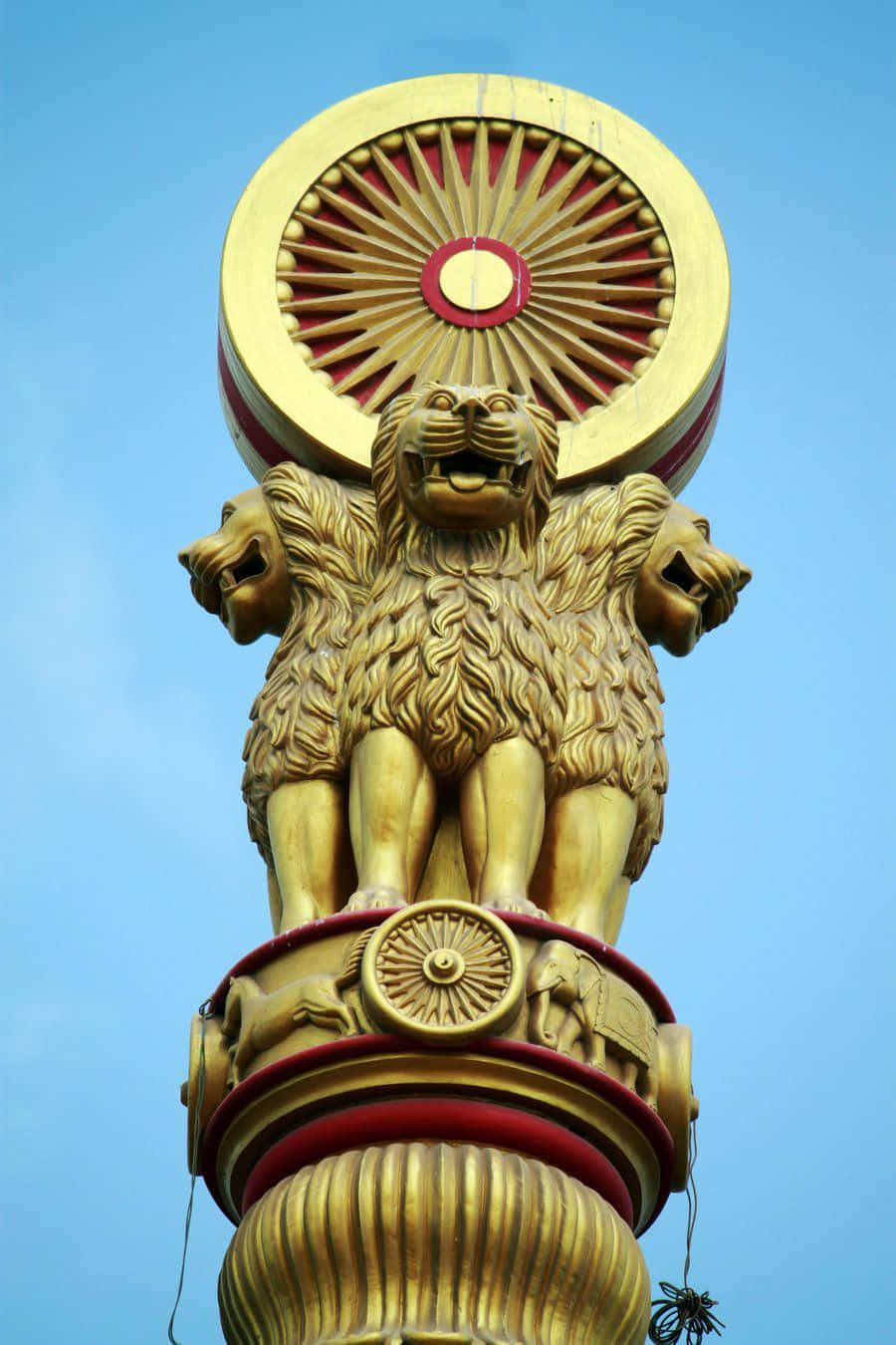 金色阿育王柱，四獅與法輪，藍天之下。