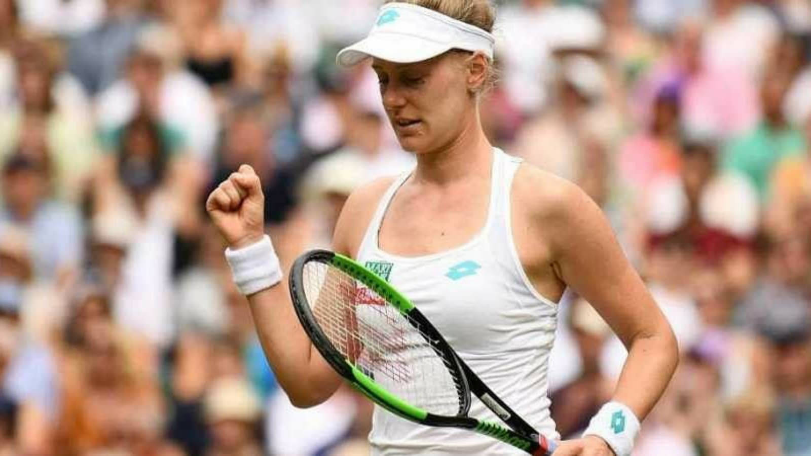 女網球運動員在草地場上握拳慶祝勝利。