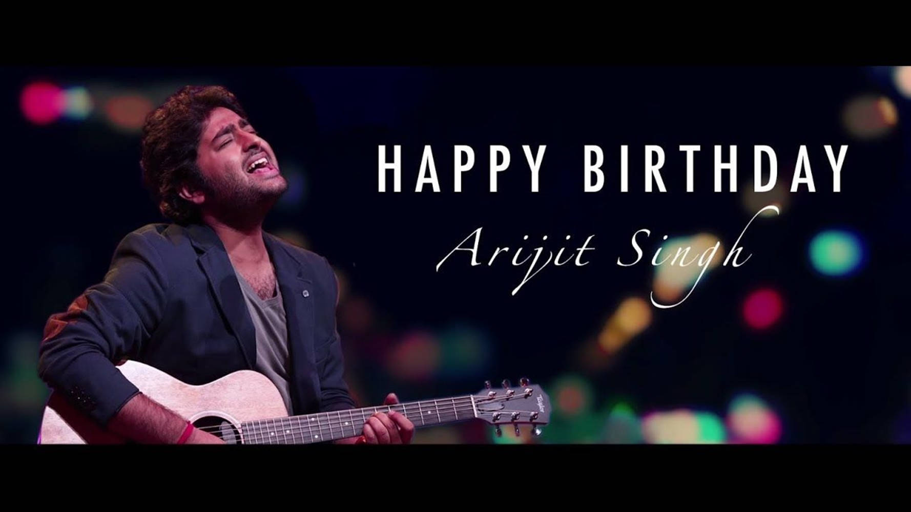 歌手Arijit Singh在舞台上彈結他，配有生日文字和彩色燈光。