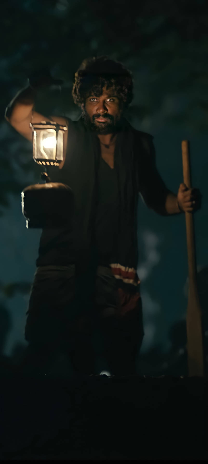 一個鬍鬚男人在黑暗的森林中夜間手持燈籠和手杖。