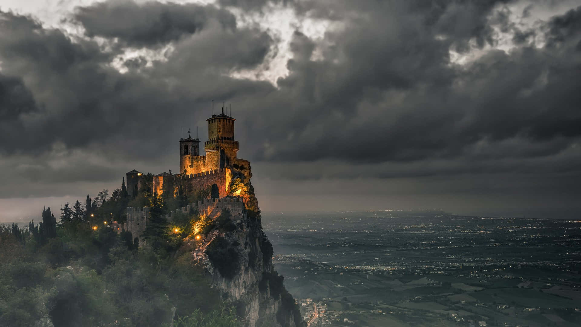 中世紀城堡在懸崖邊緣亮起，暴風雨夜空下俯瞰山谷。