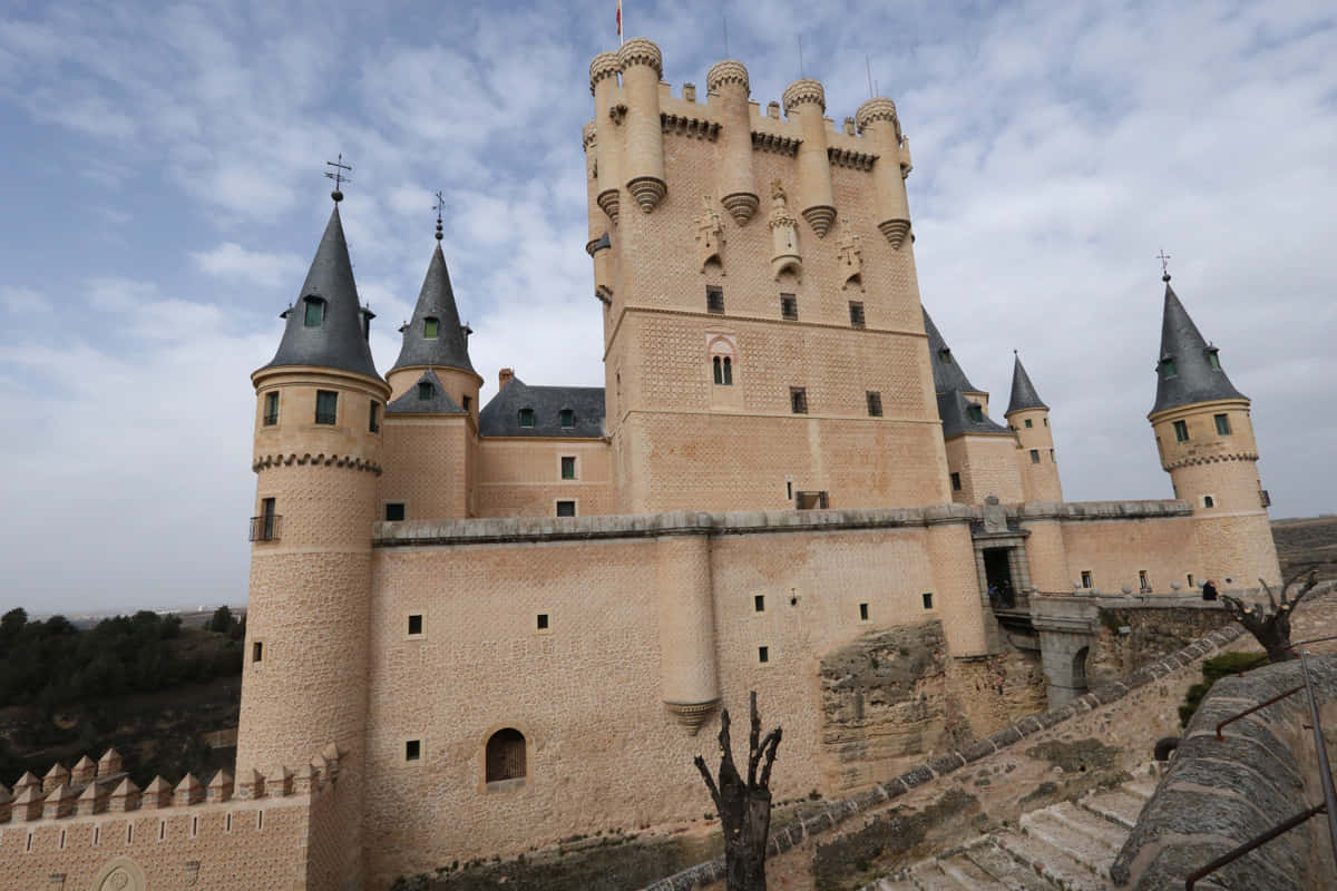 陰雲天空下，帶有尖塔的古老石城堡。
