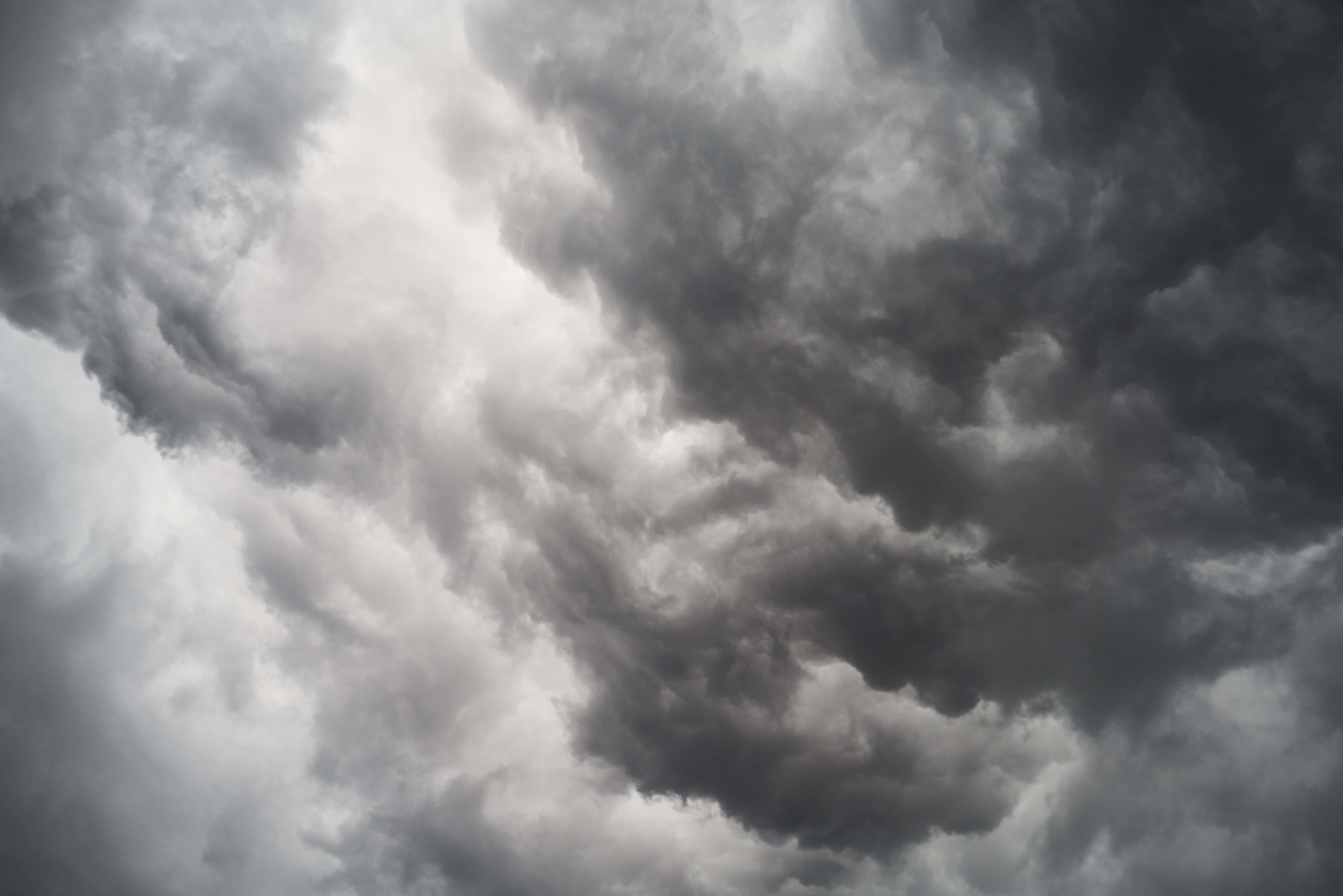 陰雲密布的天空 壁紙 — 單色調的戲劇性旋轉風暴雲層，以不祥的紋理和深度充滿天空。