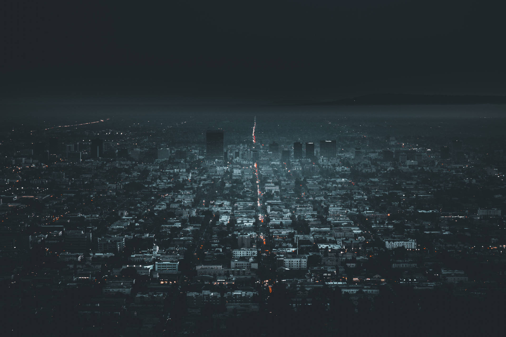 夜間鳥瞰密集的城市景觀，街道和建築物燈火通明。