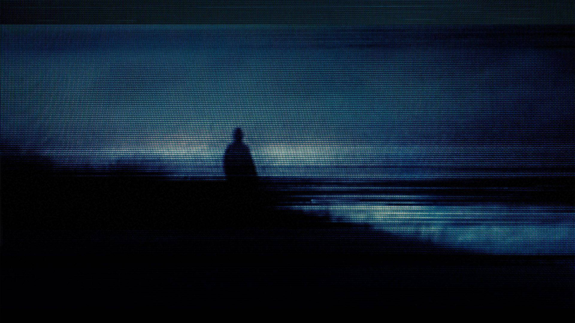 一個人在黑暗的海灘上獨自站立，天空是帶有數位偽影的扭曲藍色。