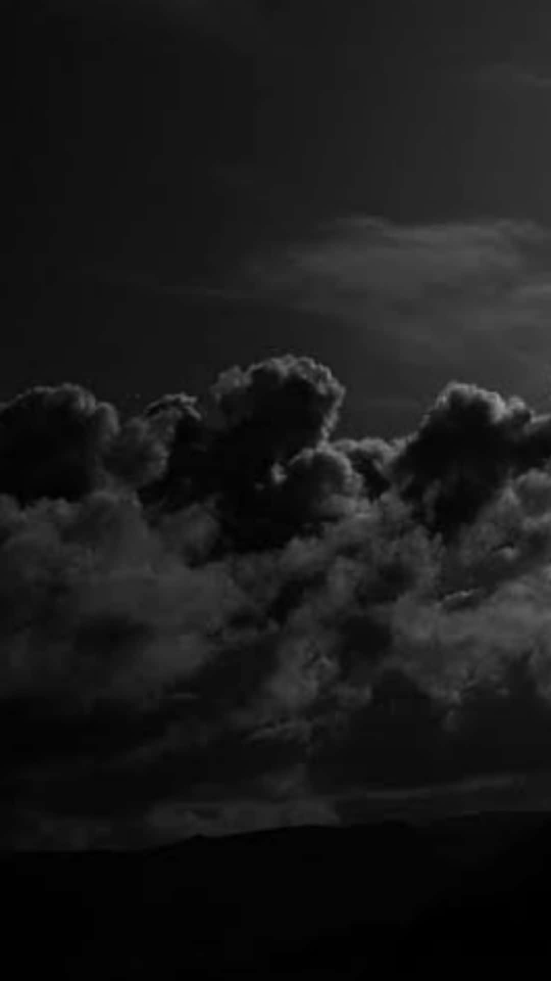 單色山脈輪廓上方的戲劇性暗雲