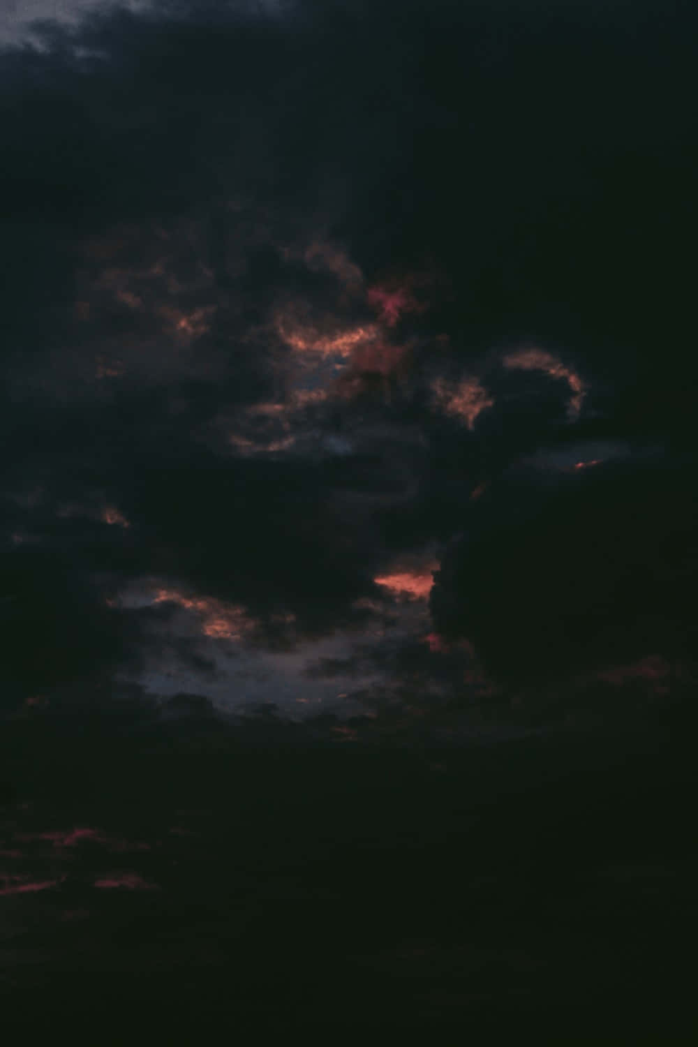 暮色中被橙色和紅色照亮的暗雲。