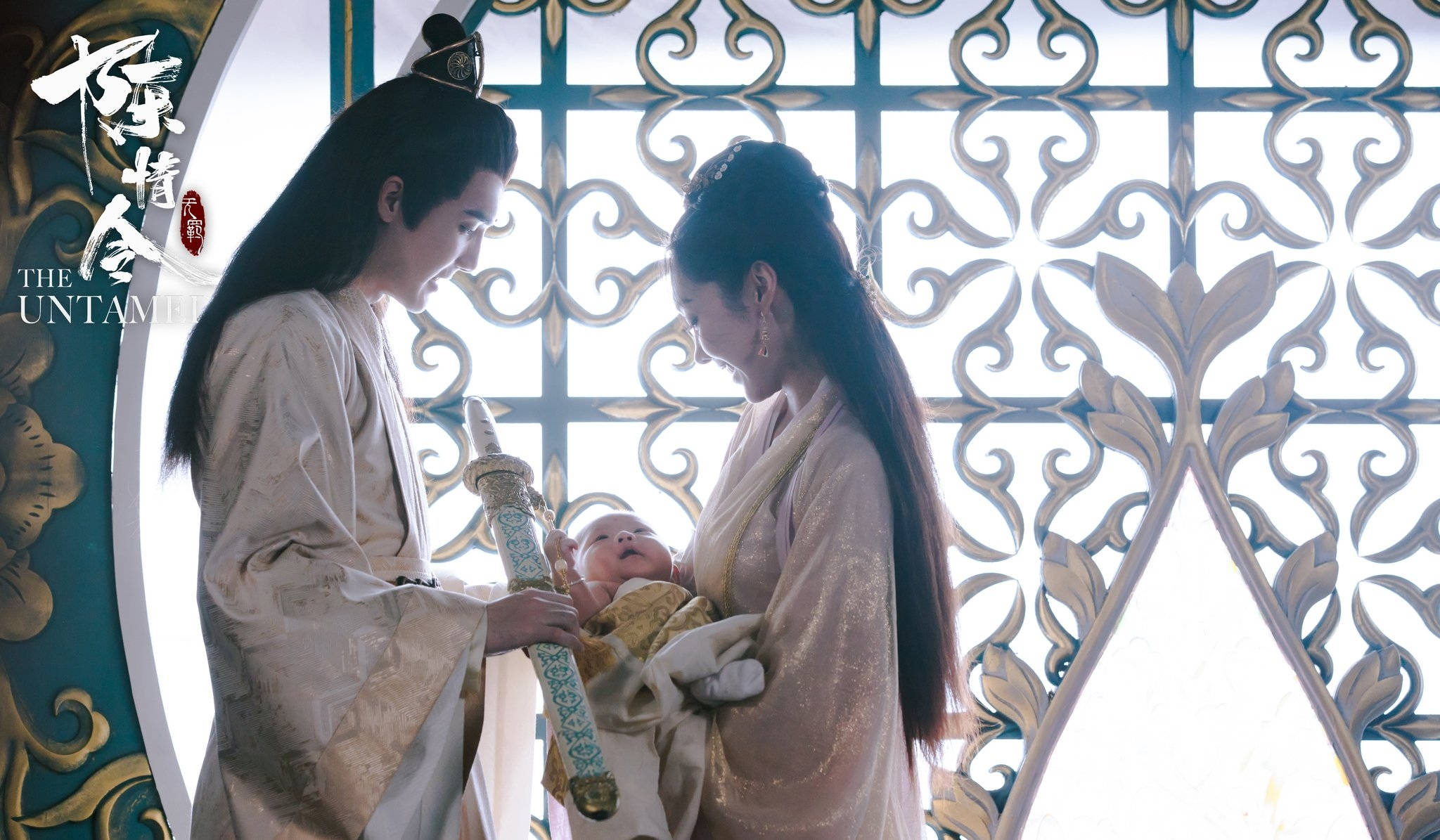 《陳情令》宣璐與嬰兒潤玉 壁紙 — 一男一女身穿飄逸古裝，在華麗的格子窗前溫柔地一起抱著一個嬰兒。