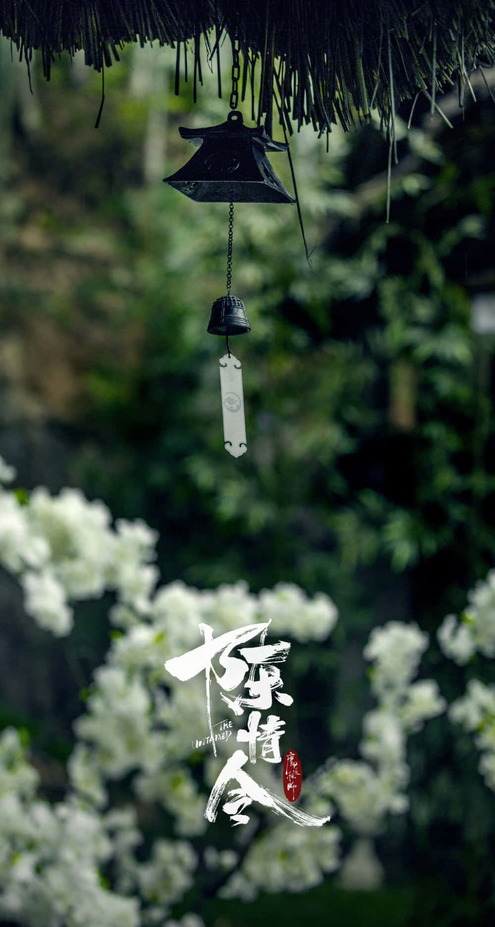 黑色風鈴懸掛在綠色花園中的白色花朵上方，帶有風格化文字。