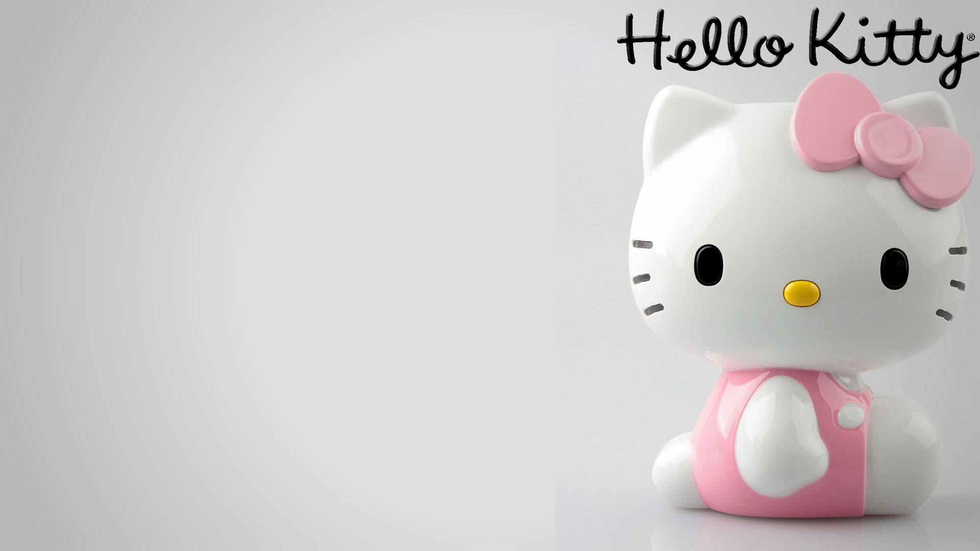 Hello Kitty公仔，帶有粉紅色蝴蝶結和連衣裙，在純灰色背景上